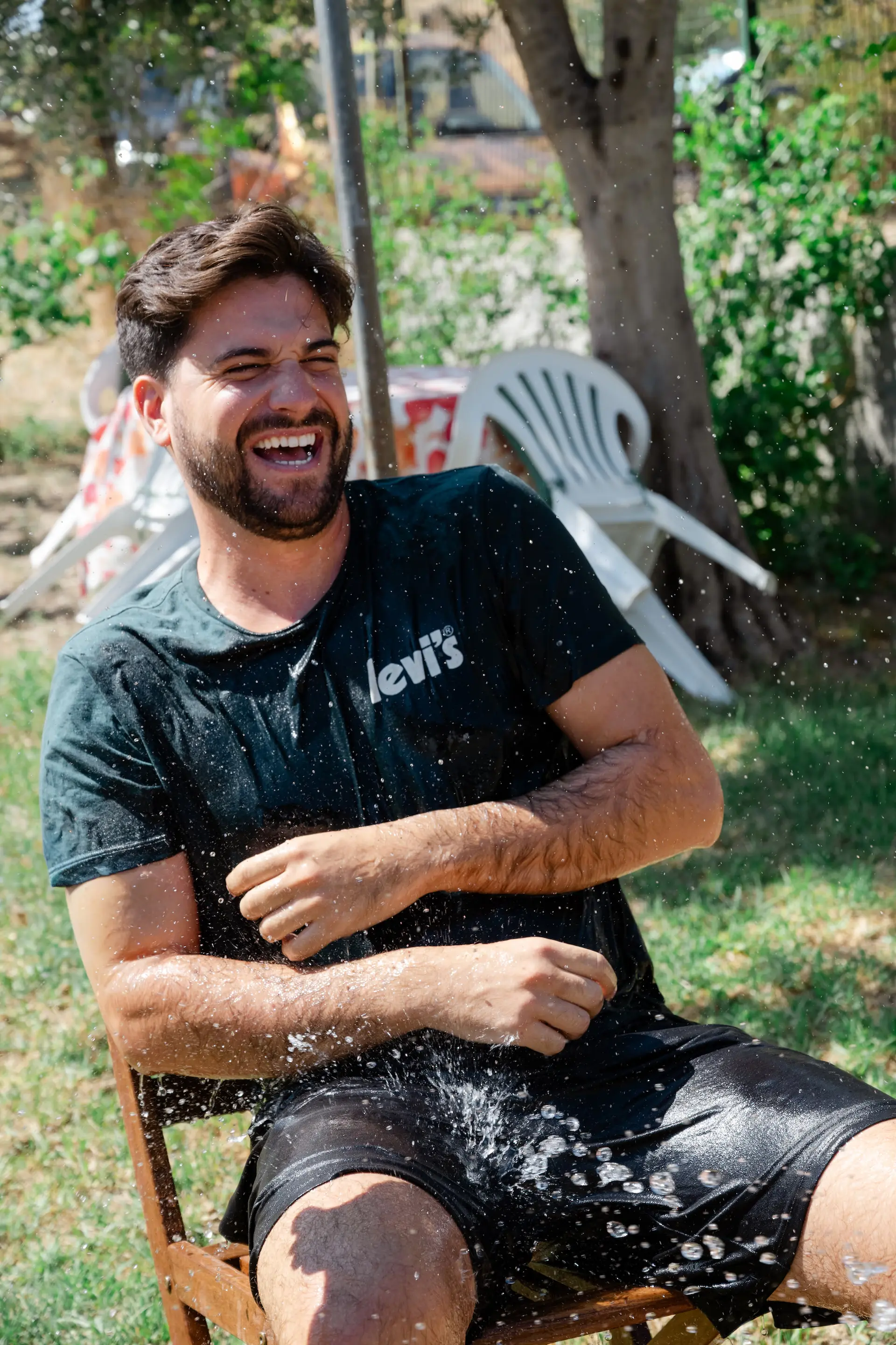 Natural light portrait of the groom sharing a laugh while getting ready for his Athens wedding