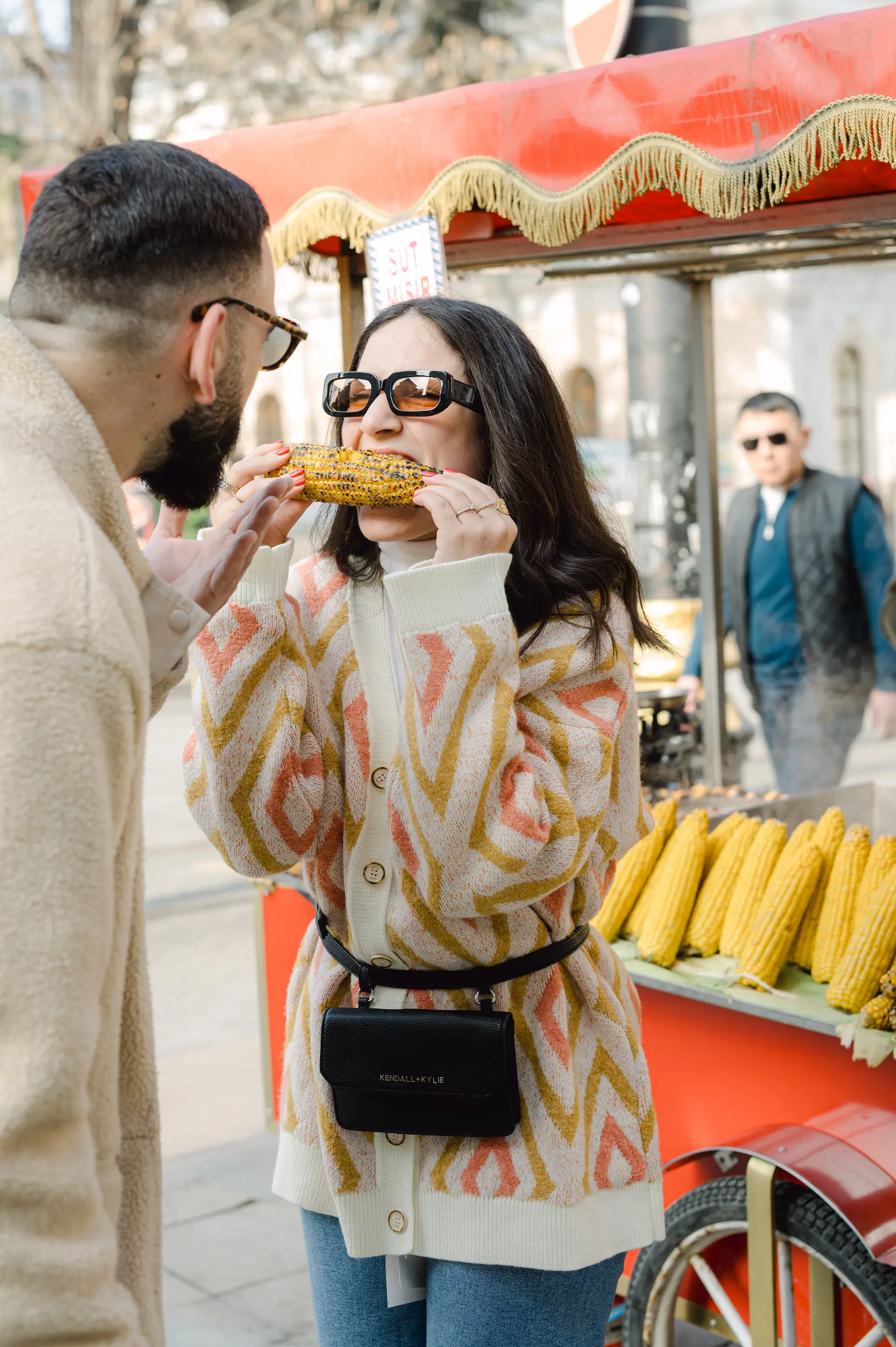 a man and woman eating corn