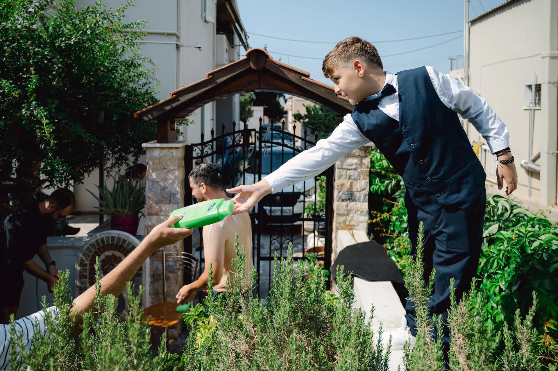 a boy reaching out to a person holding a shampoo