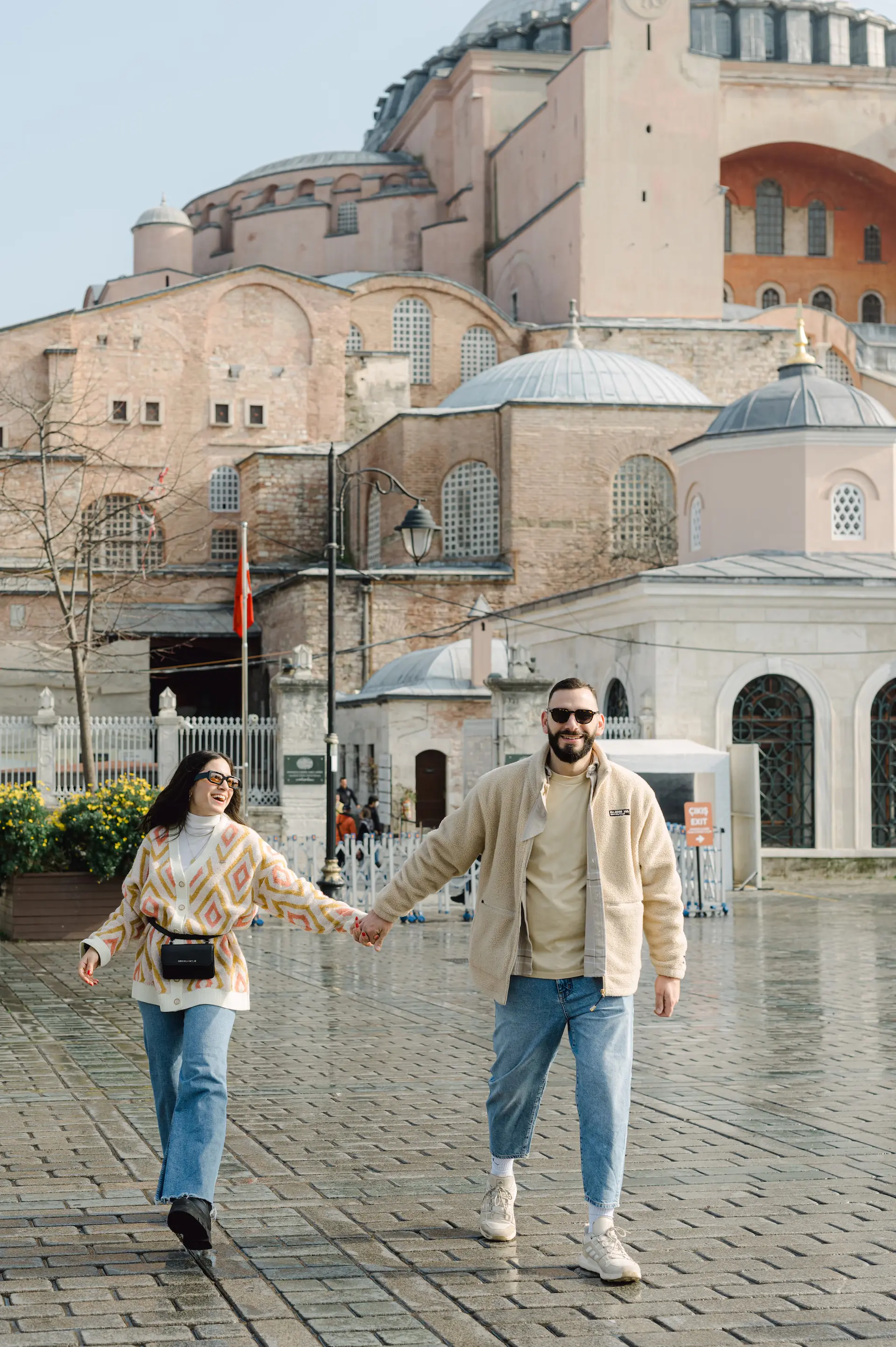 a man and woman holding hands in front of a building