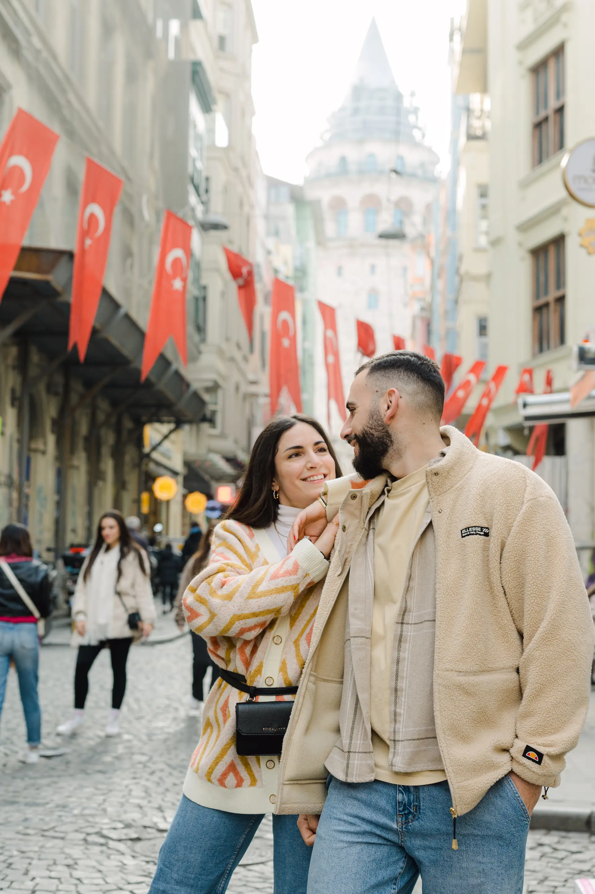 a man and woman standing on a street with flags