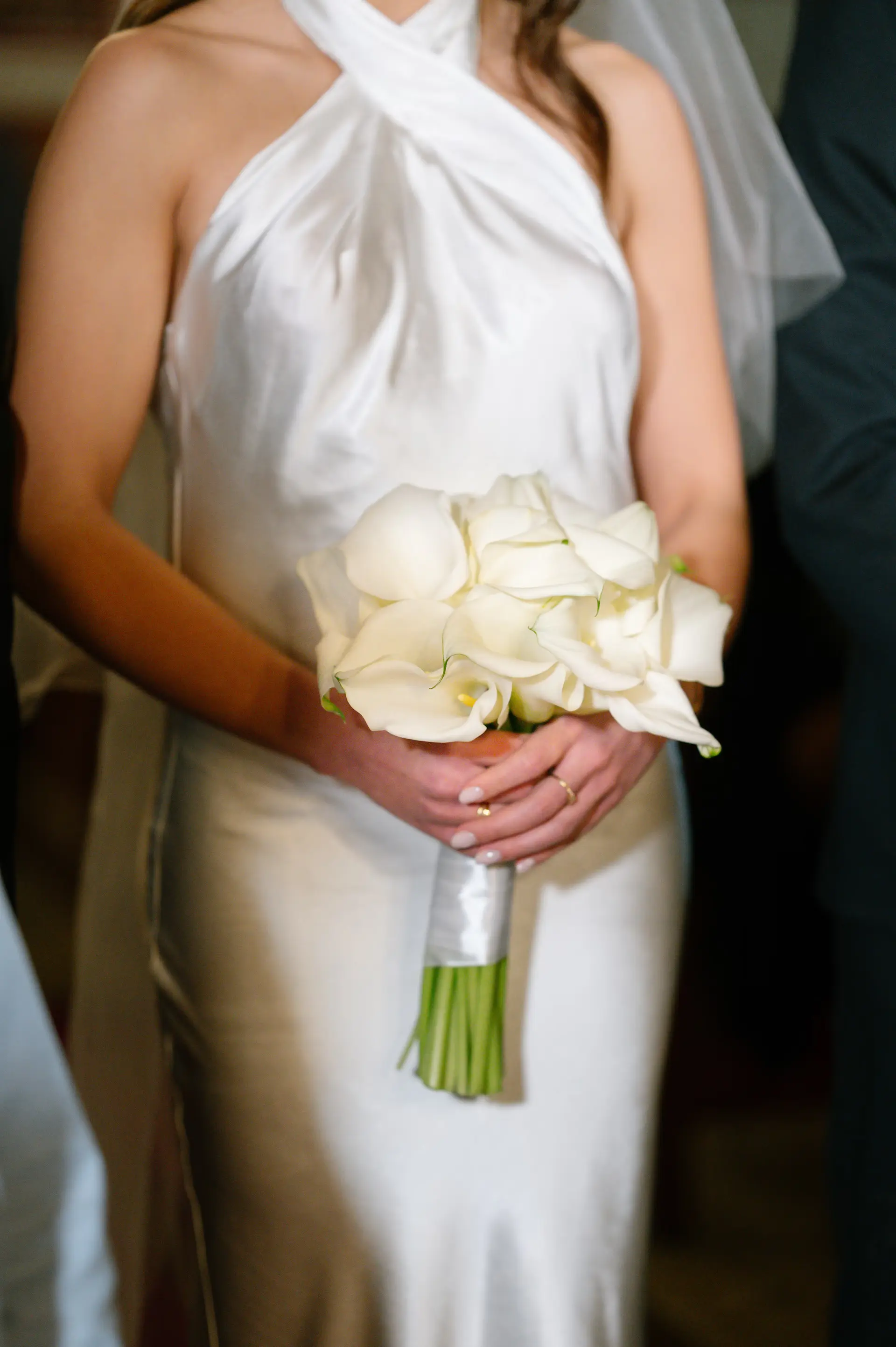 a person in a white dress holding a bouquet of white flowers