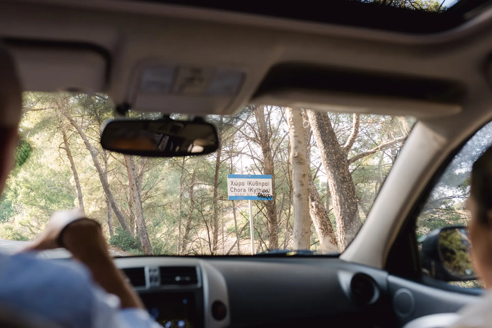 candid photo inside the car with the sign Kythira