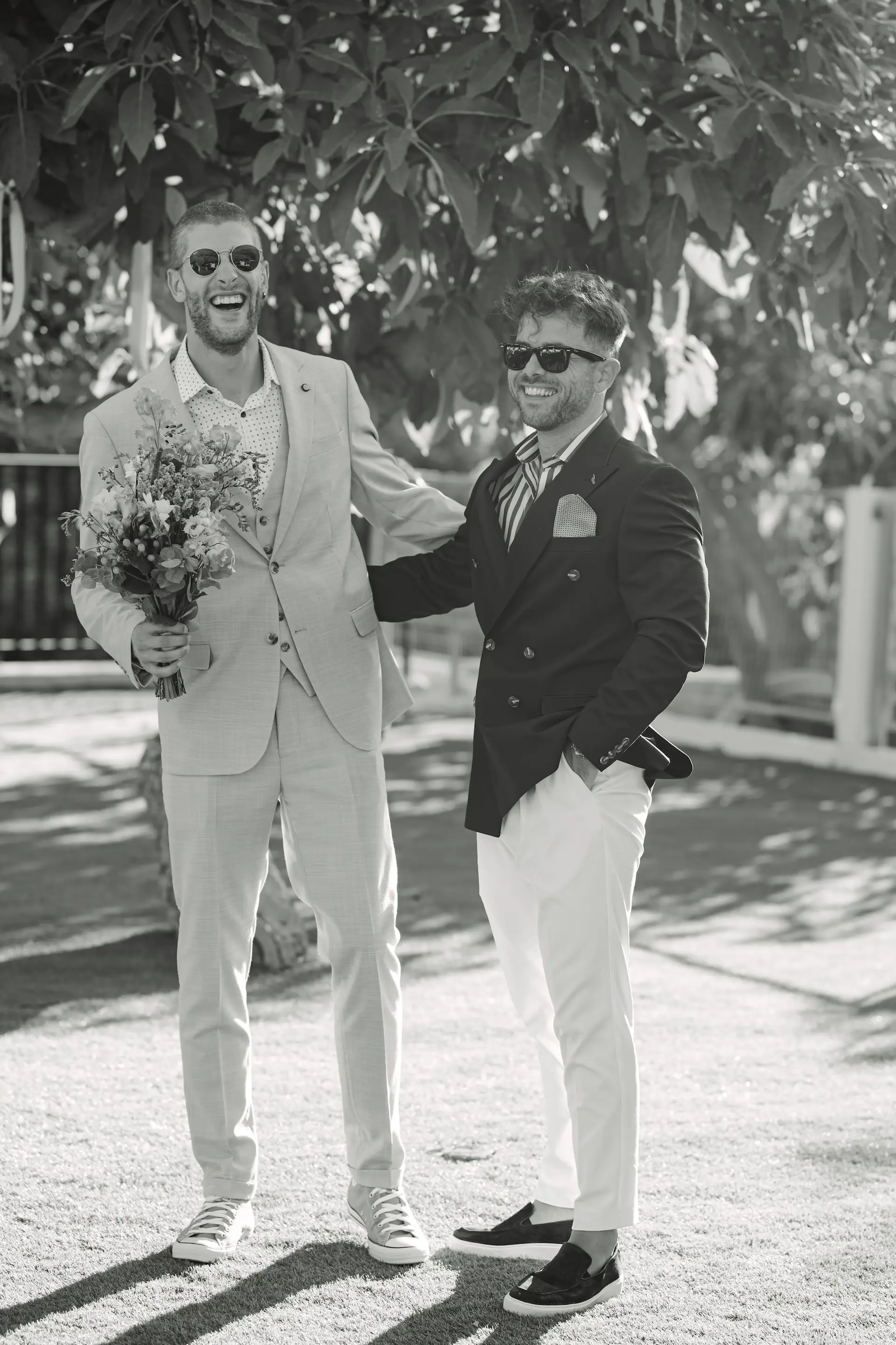candid photo of groom and his best man in black and white