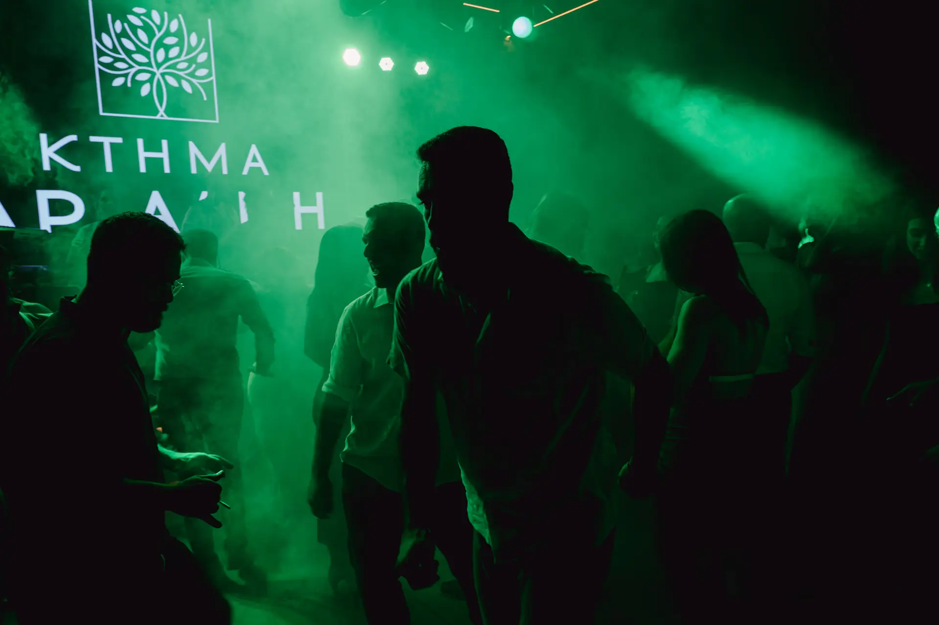 a group of people dancing in party floor with green lights