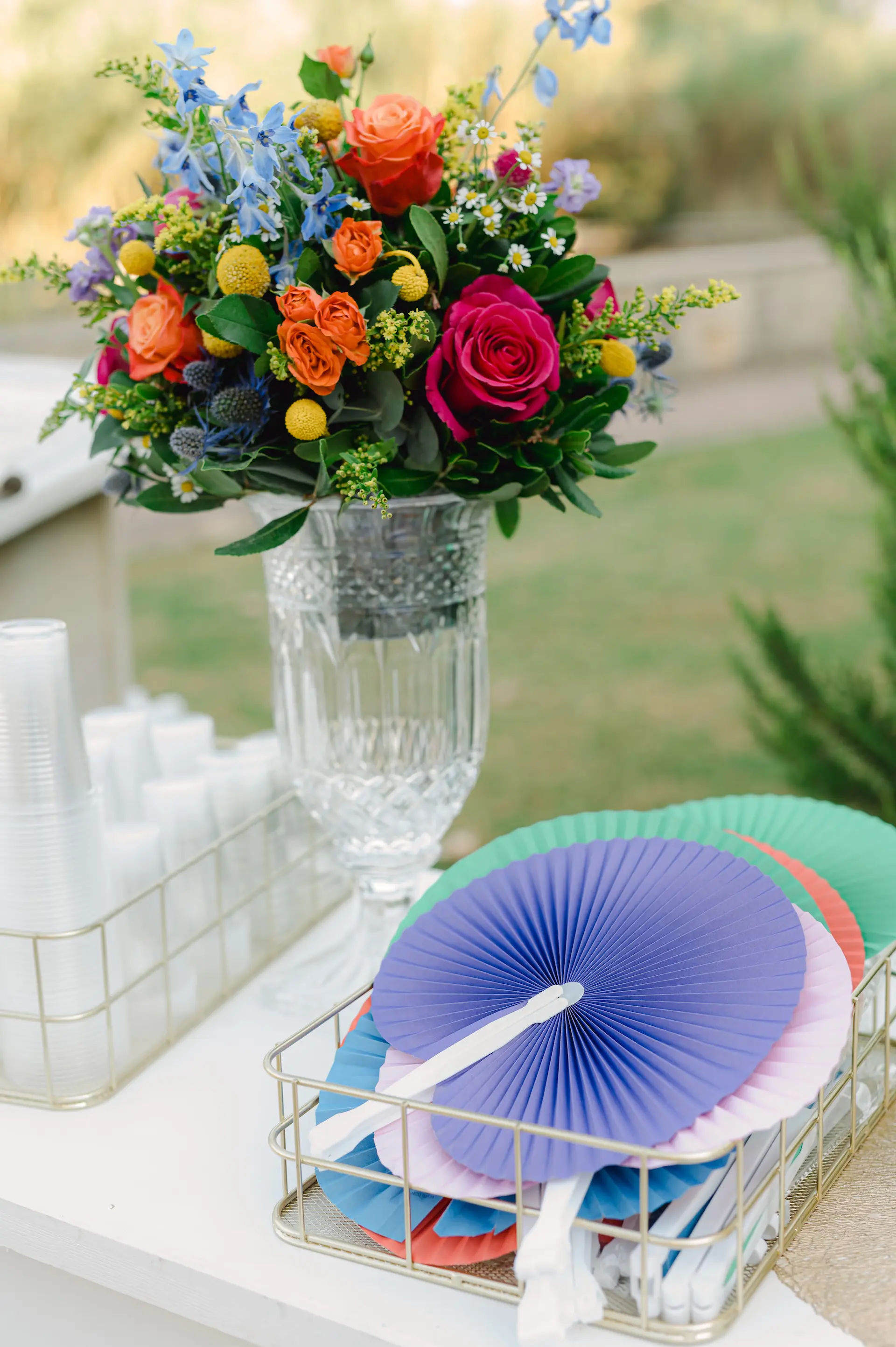 a bouquet of flowers and paper fans on a table
