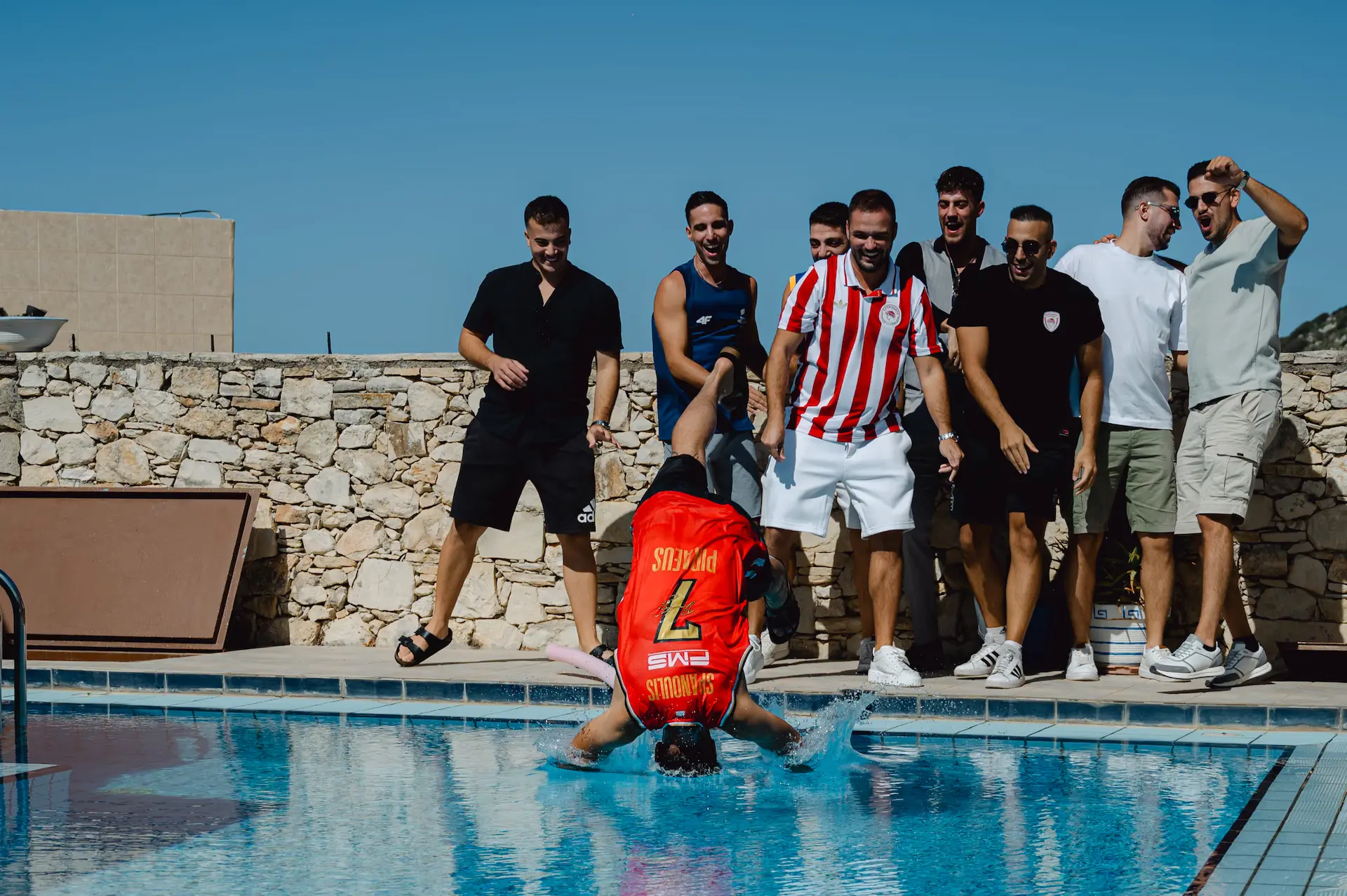 groom gets thrown into the pool by his friends