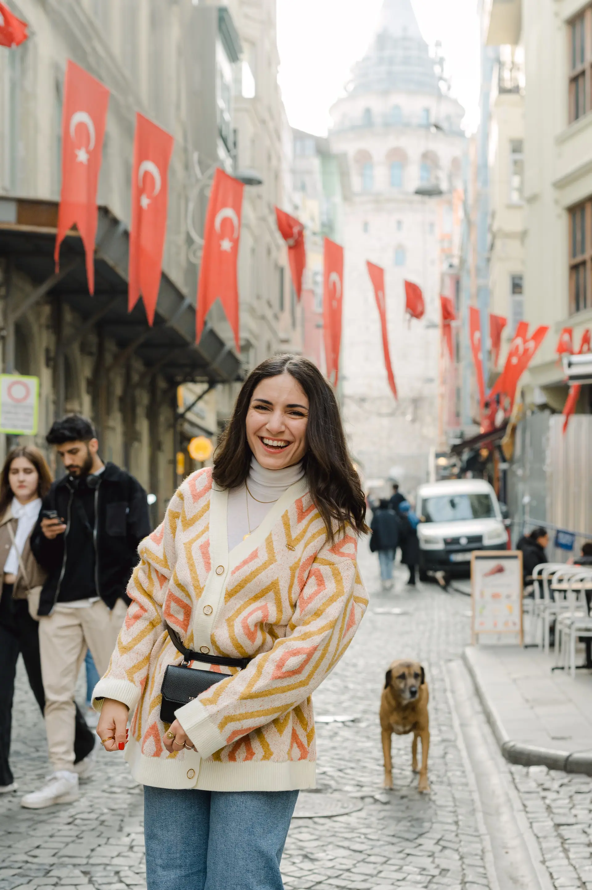 a woman smiling with a dog on a street