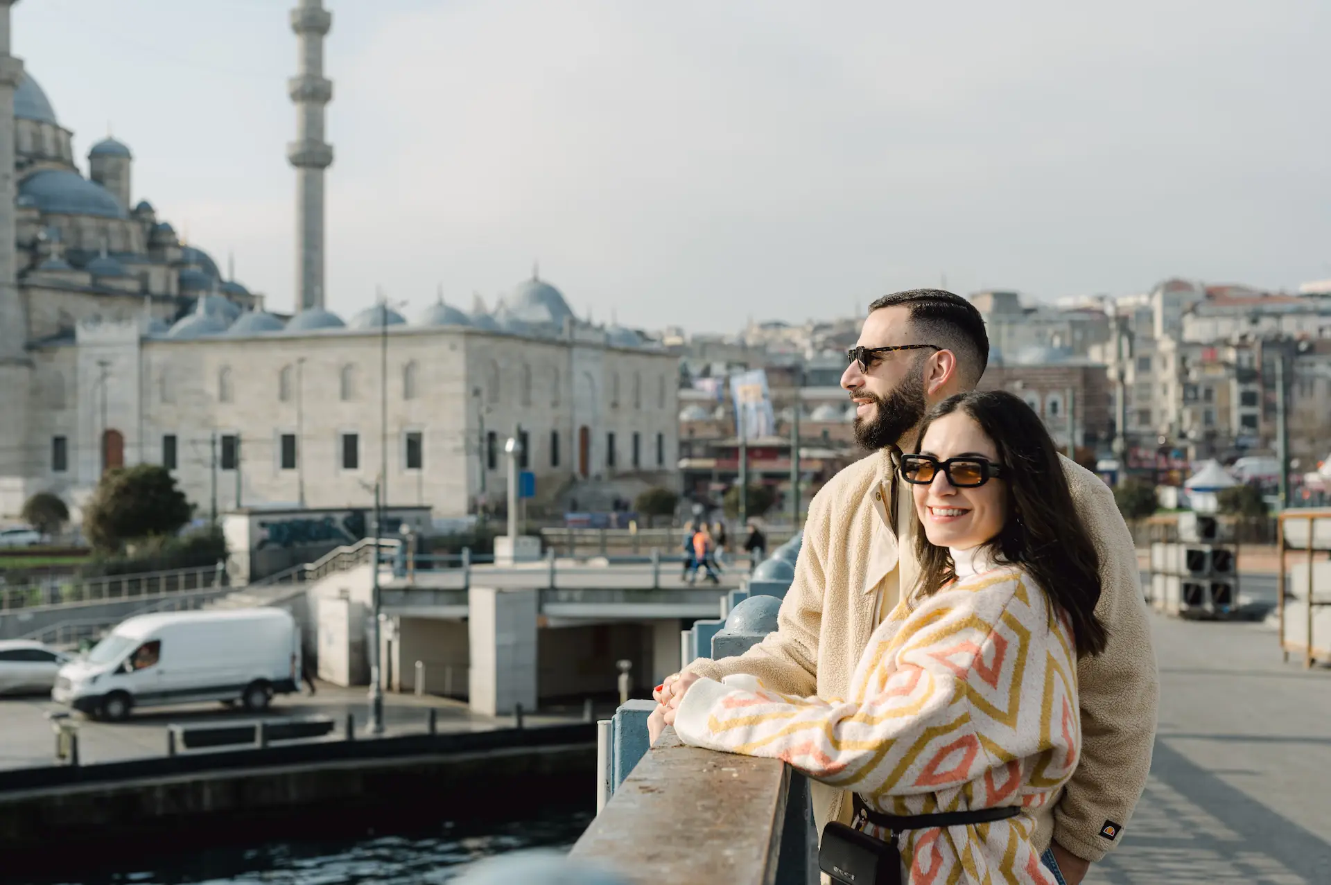 a man and woman leaning on a railing