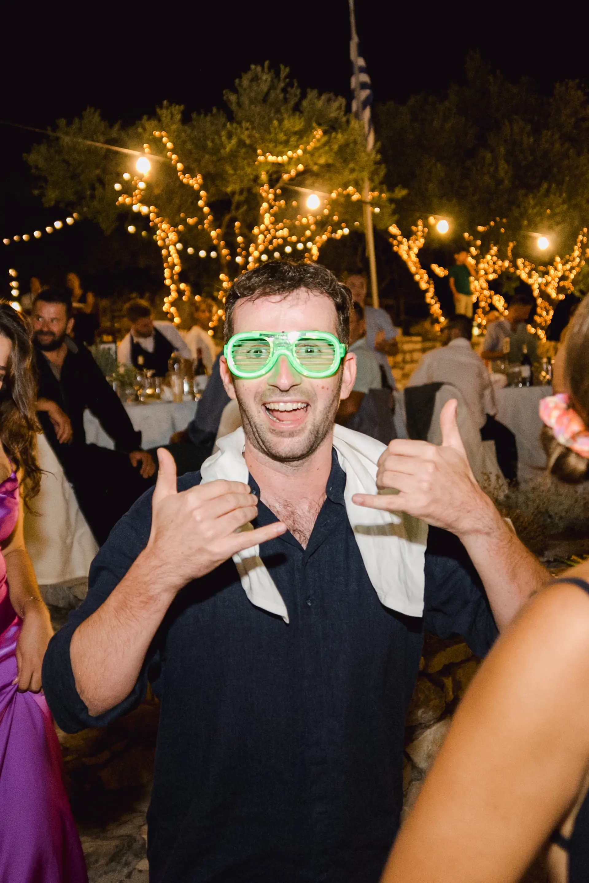 a man in green glasses making hand gestures