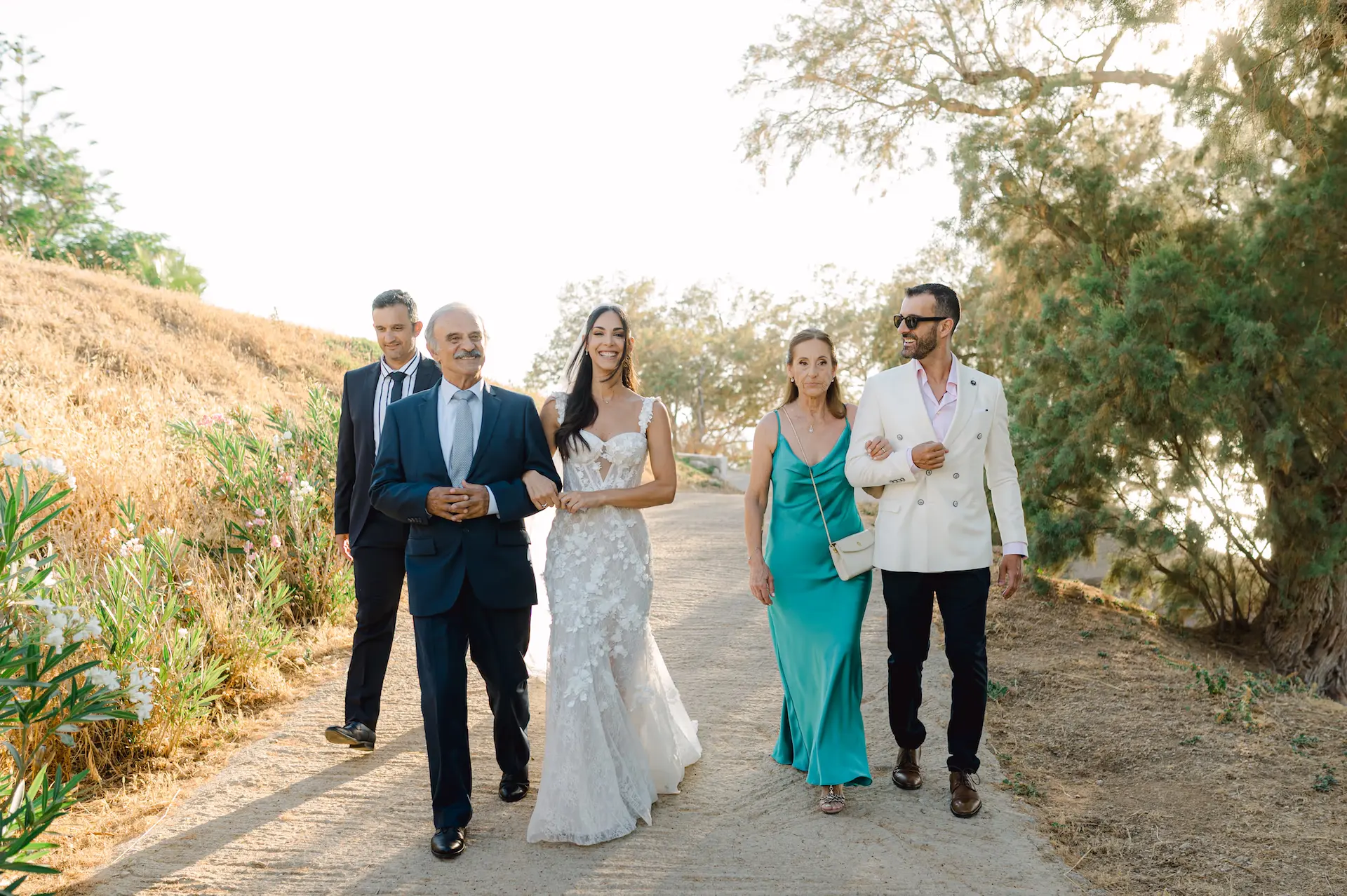 Candid shot of a bride walking down the aisle with her family, capturing a simple and emotional moment.