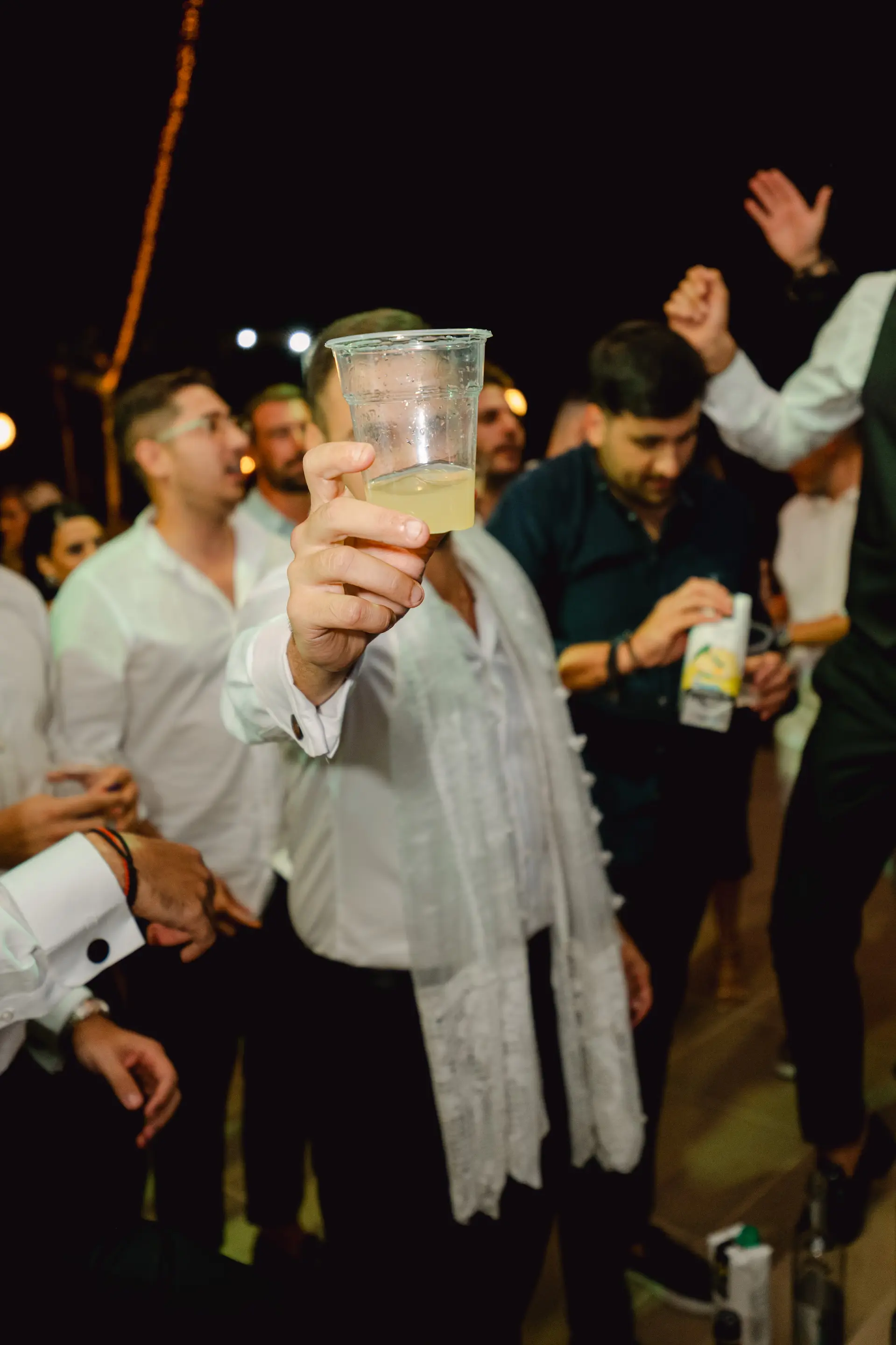 a person holding a plastic cup with a drink in it