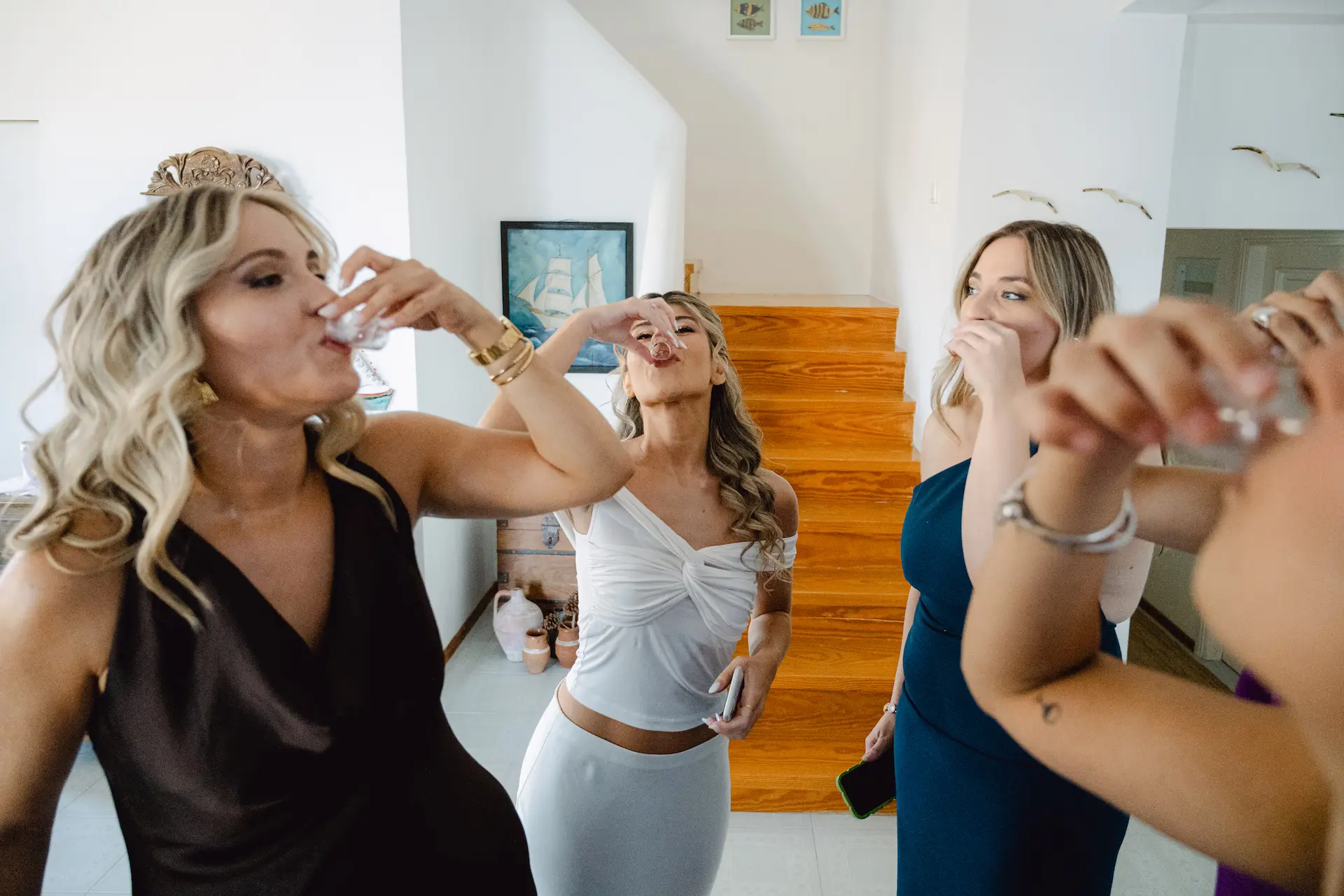Fun candid moment of the bride having a drink with her best friends
