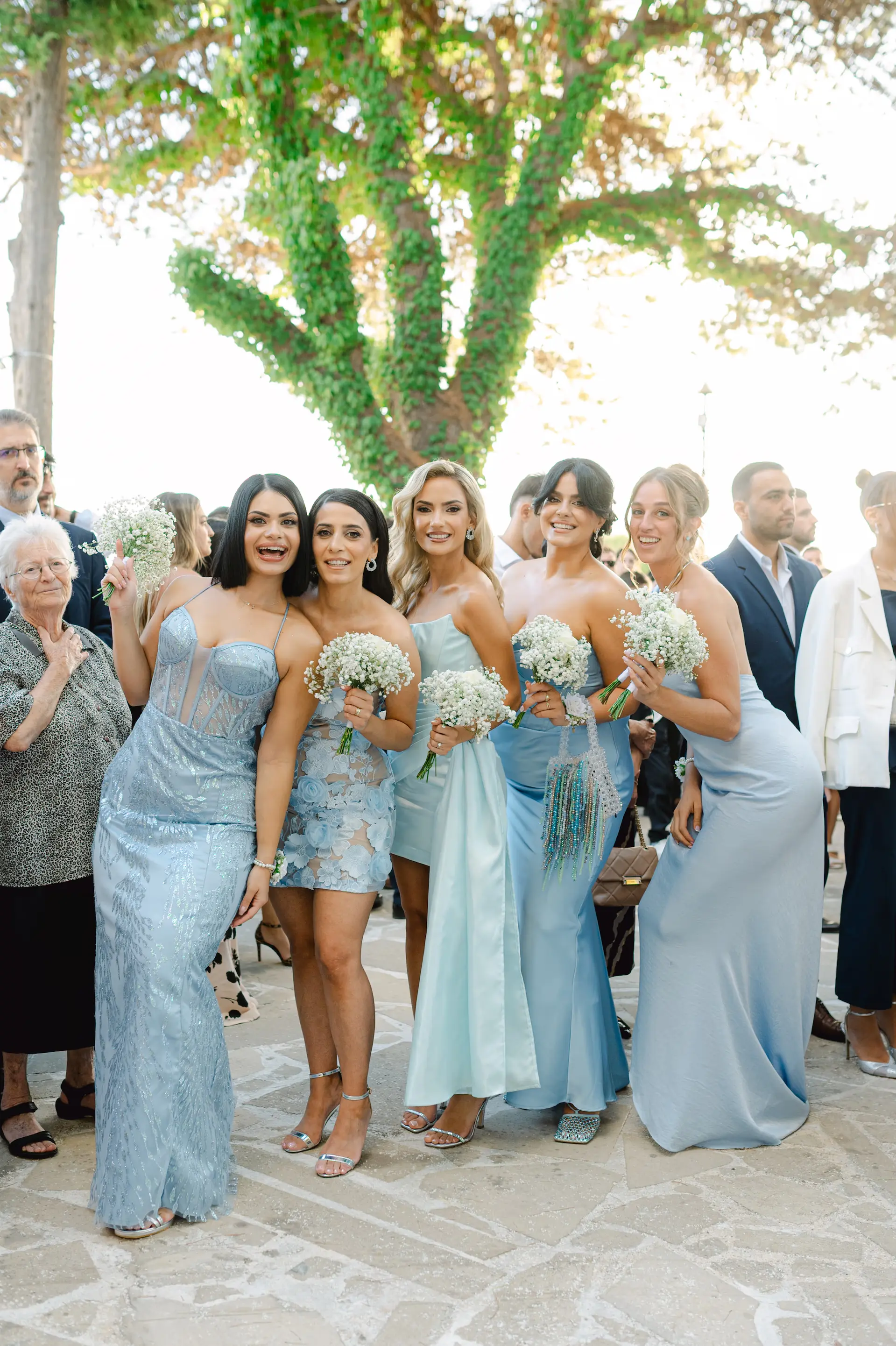 bachelorette with their blue dresses and bouquets during ceremony