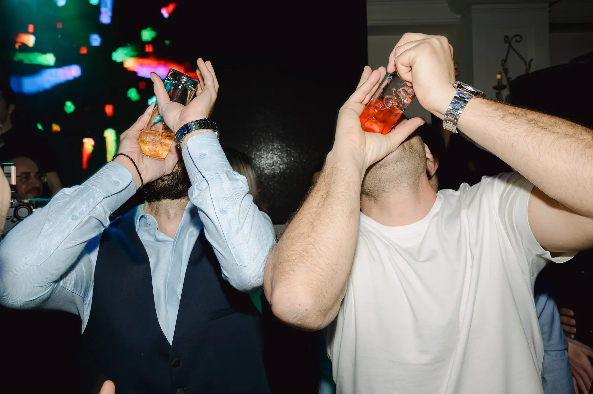 a group of men holding up drinks