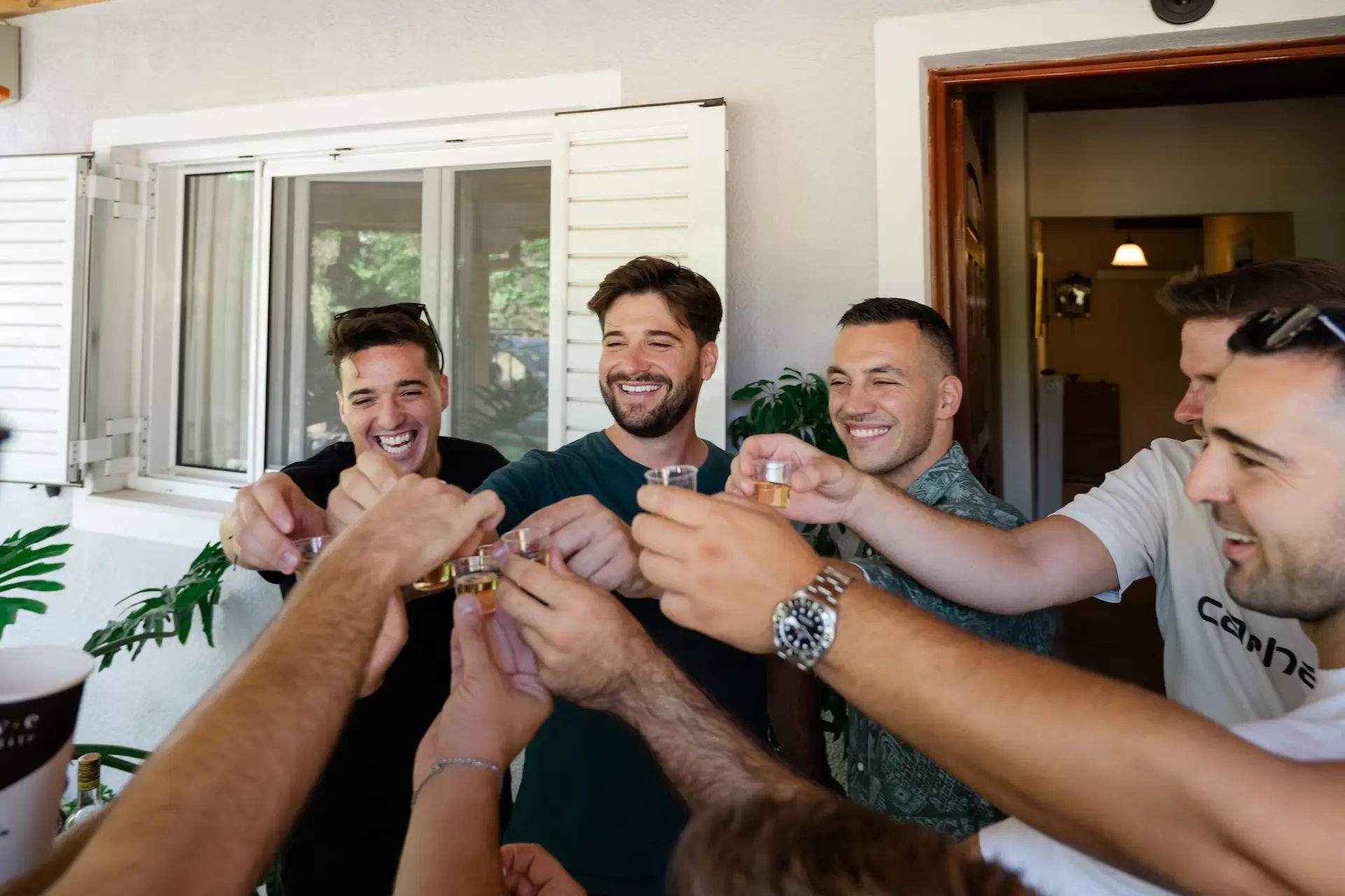 Group of groomsmen drinking and raising a toast to the groom