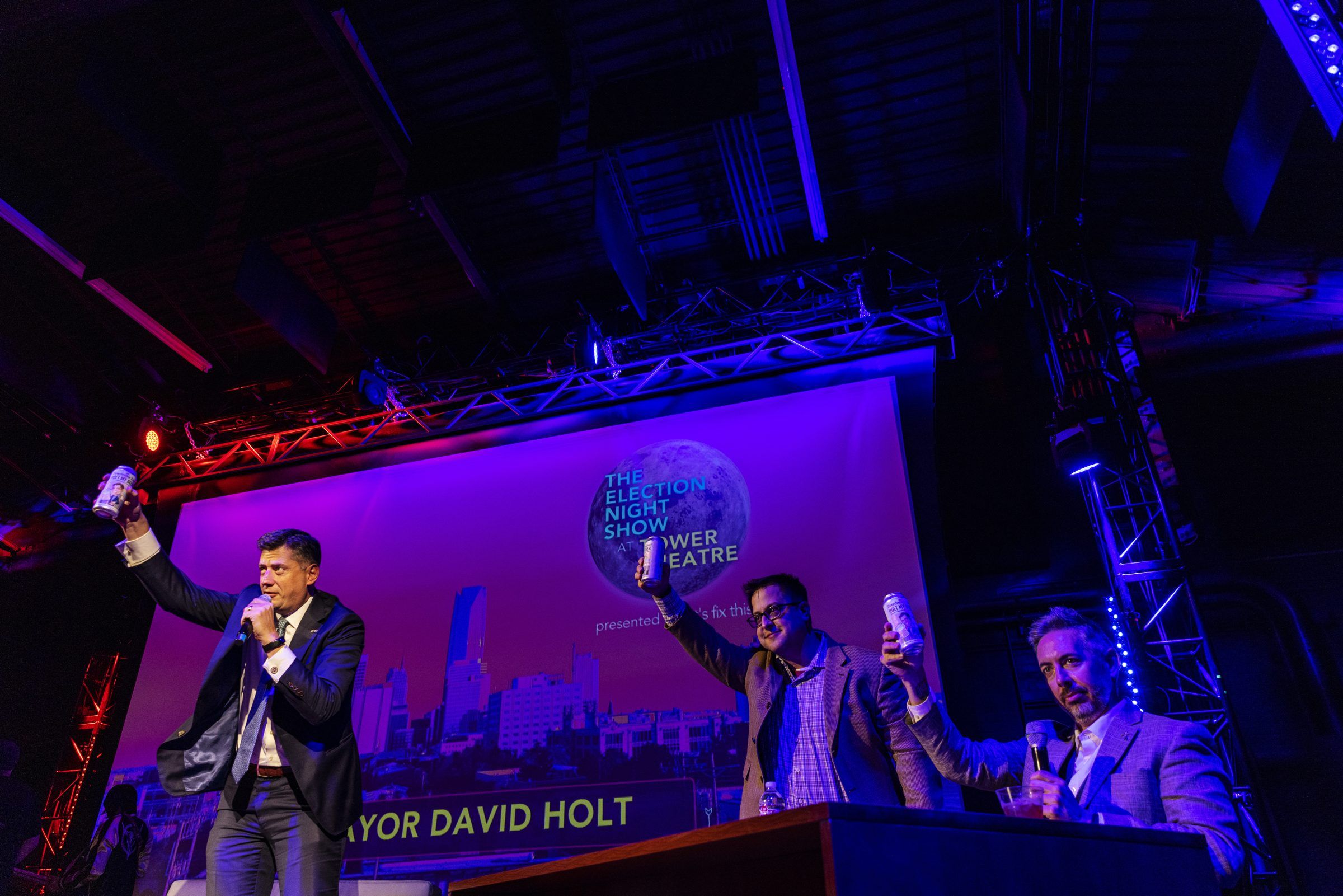 Mayor David Holt raises a can in a toast with the two hosts on the 2022 Election Night Show stage.