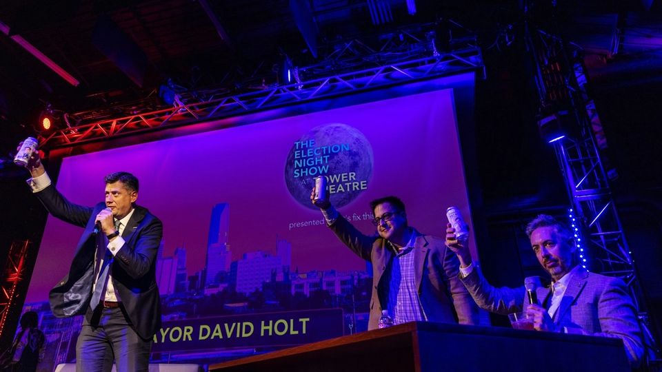 Mayor David Holt raises a can in a toast with the two hosts on the 2022 Election Night Show stage.
