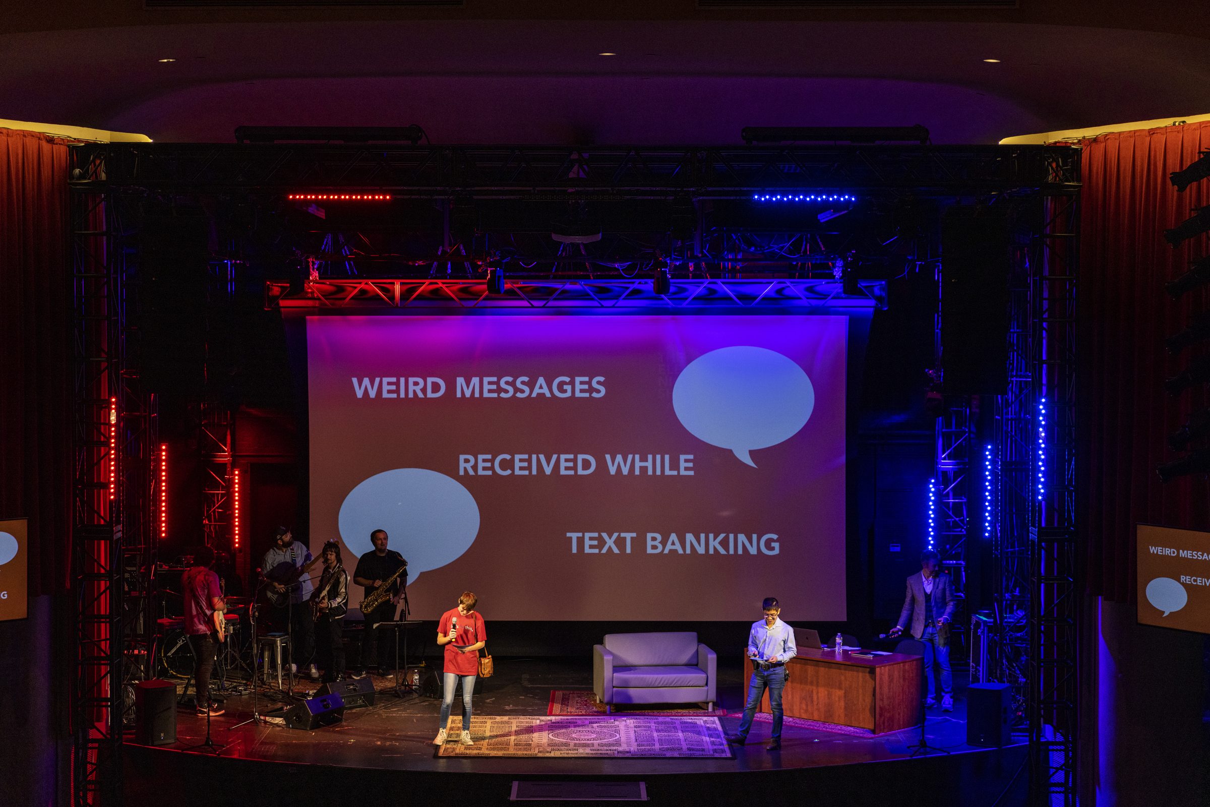 A wide view of the stage and a big screen reading "Weird messages received while text banking."