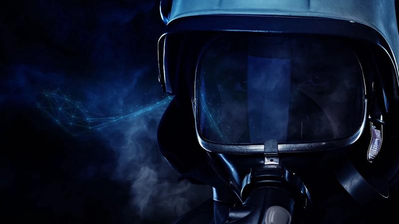 Nahaufnahme auf Helm einer Einsatzkraft der Feuerwehr vor rauchendem Hintergrund