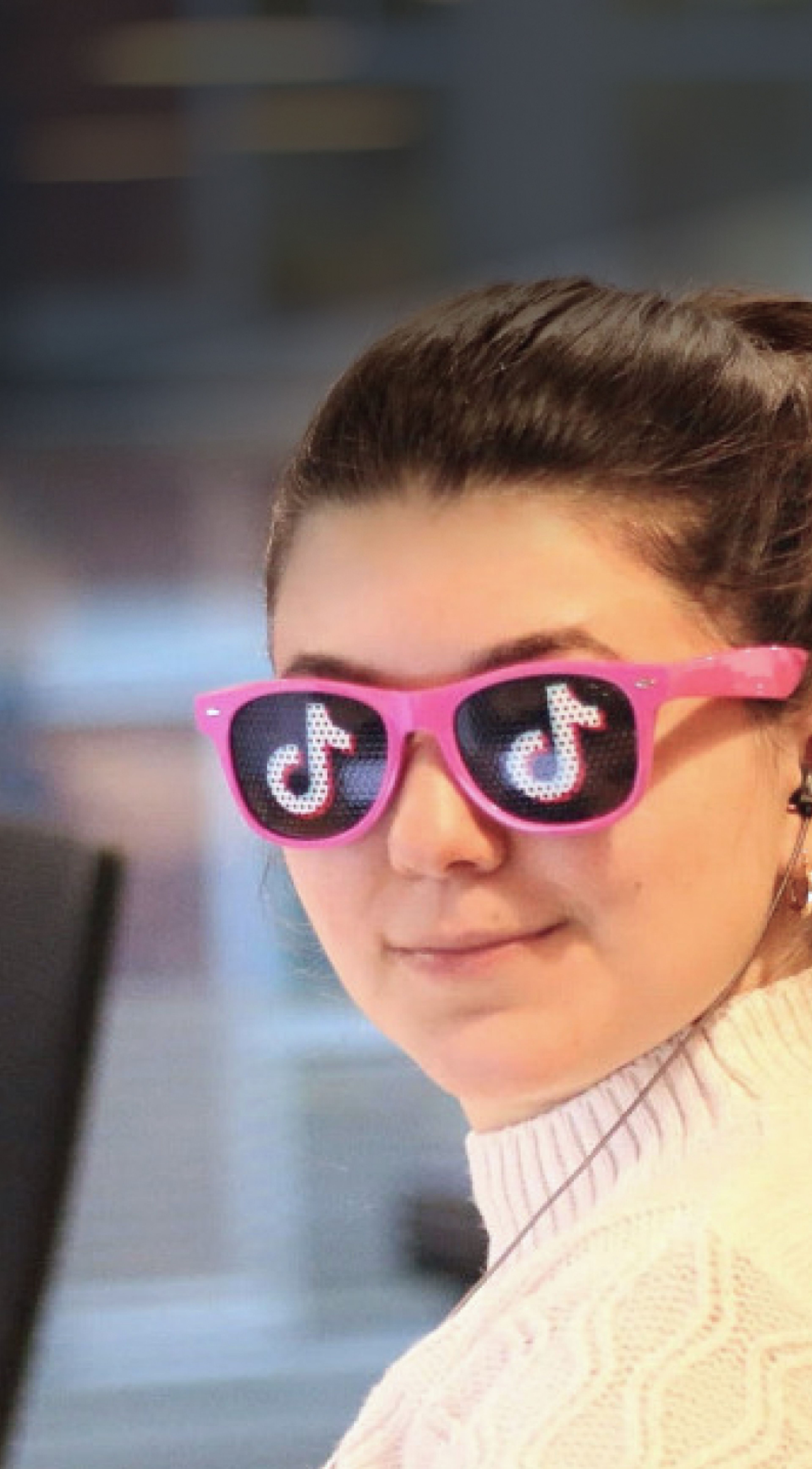  Headshot of a female TikTok employee who wears pink-rimmed glasses with a TikTok music note on each lens.