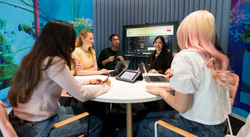 Seven participants in TikTok's Project Intern Program pose together holding boba beverages in an office setting.