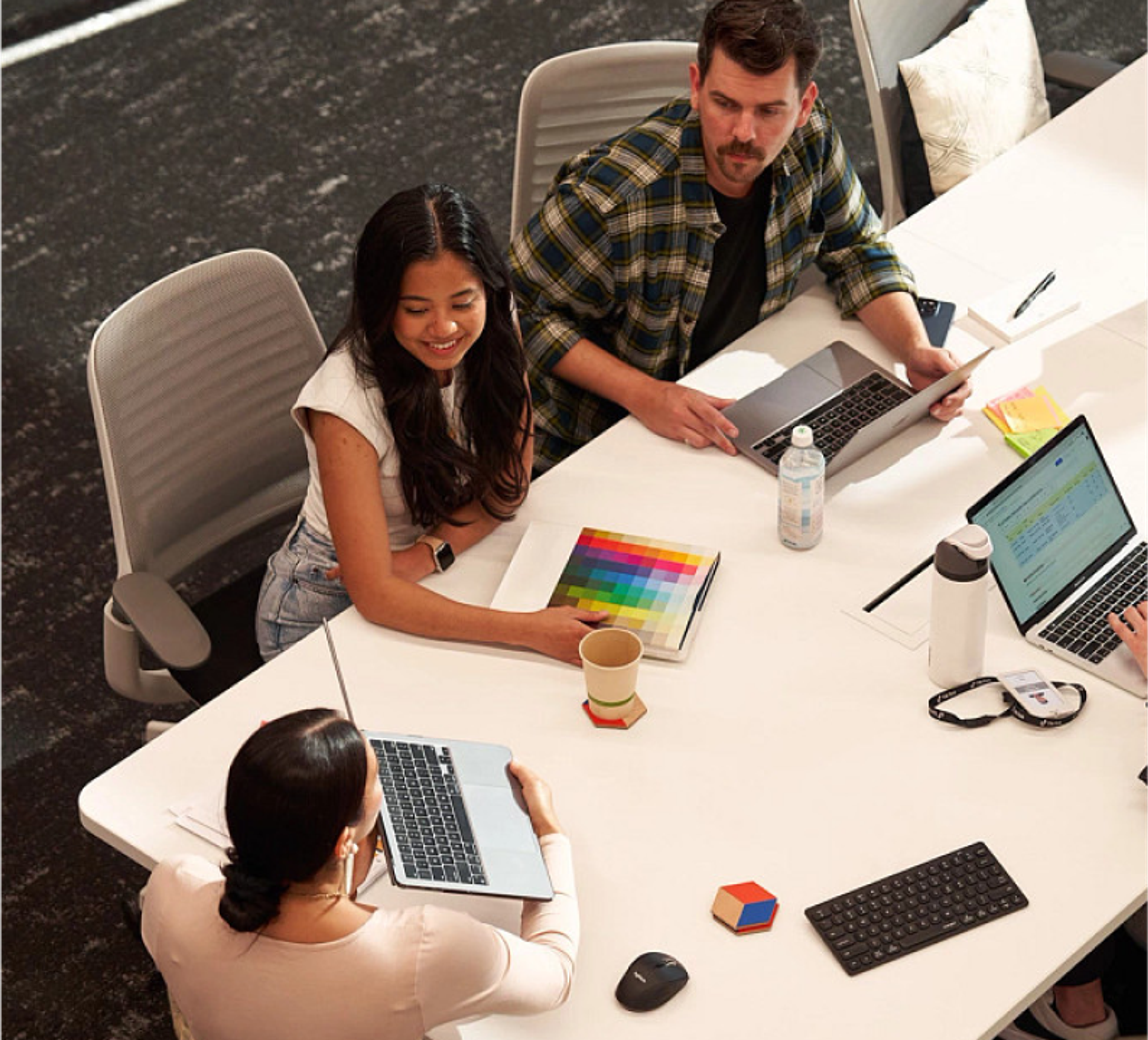 Three ByteDance employees sit and work together at a conference room table.