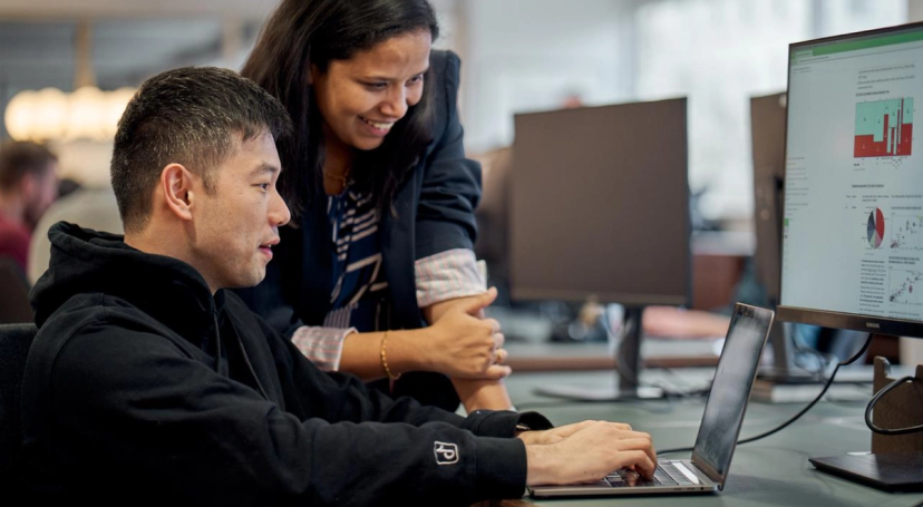 Two TikTok Summer Ph.D. students work together at a computer.