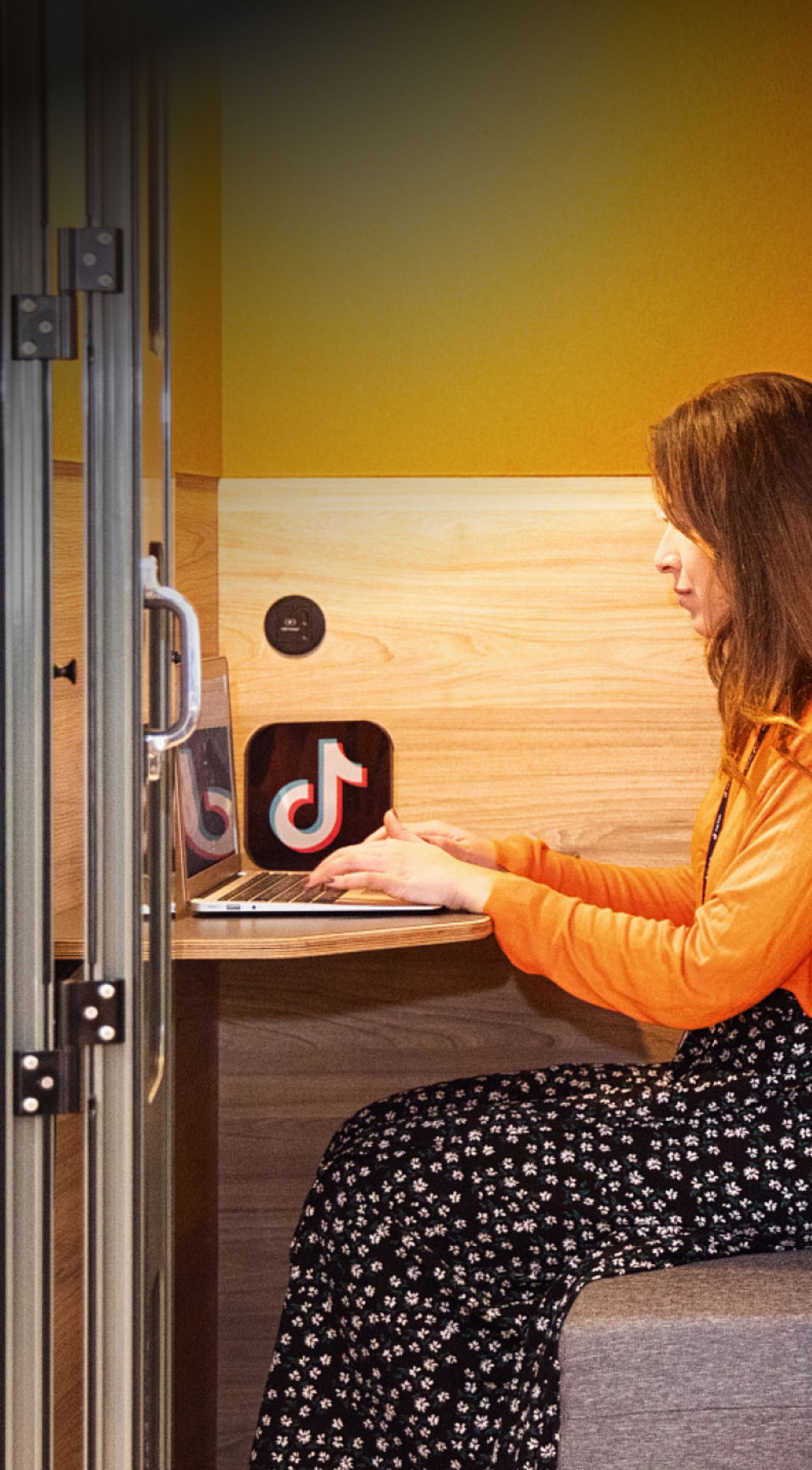 A female TikTok employee sits and works on her laptop.