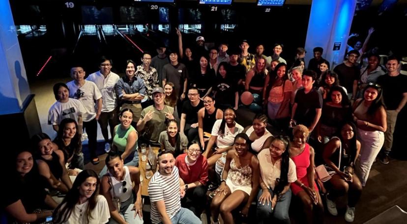 An overhead view of a large group of TikTok Summer Interns as they smile and pose for a picture together.