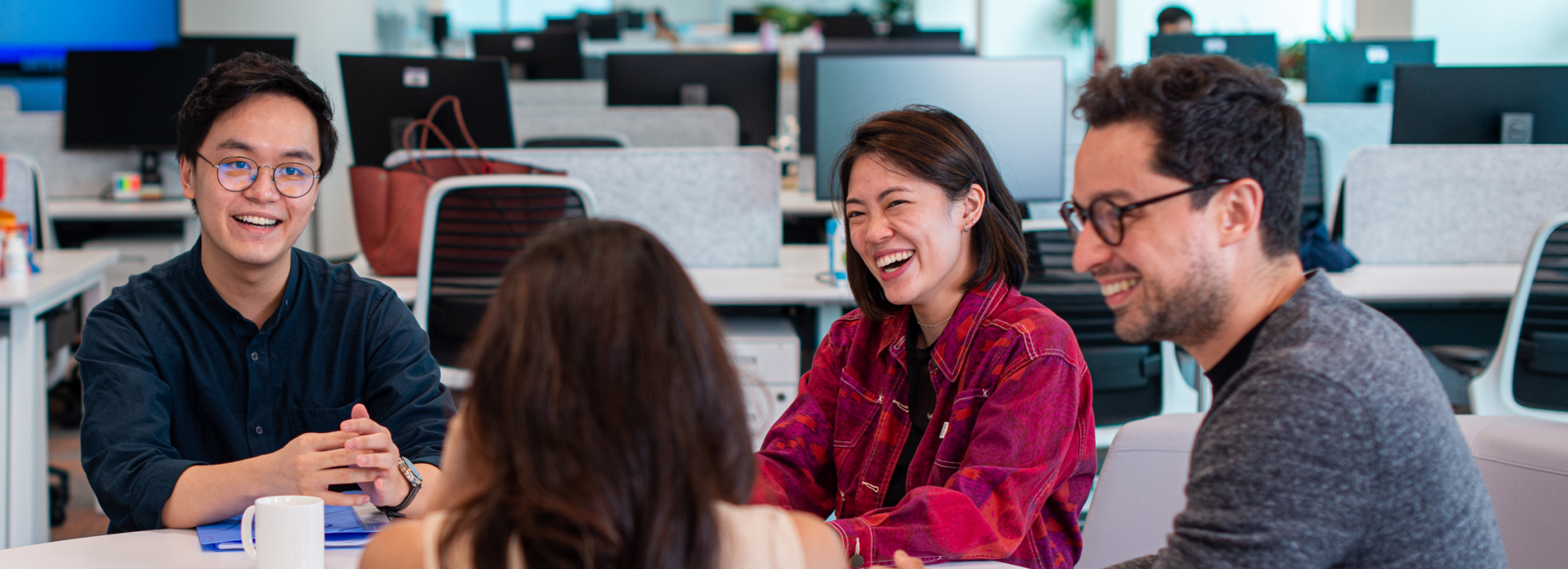 A group of male and female ByteDance employees laugh and talk together.