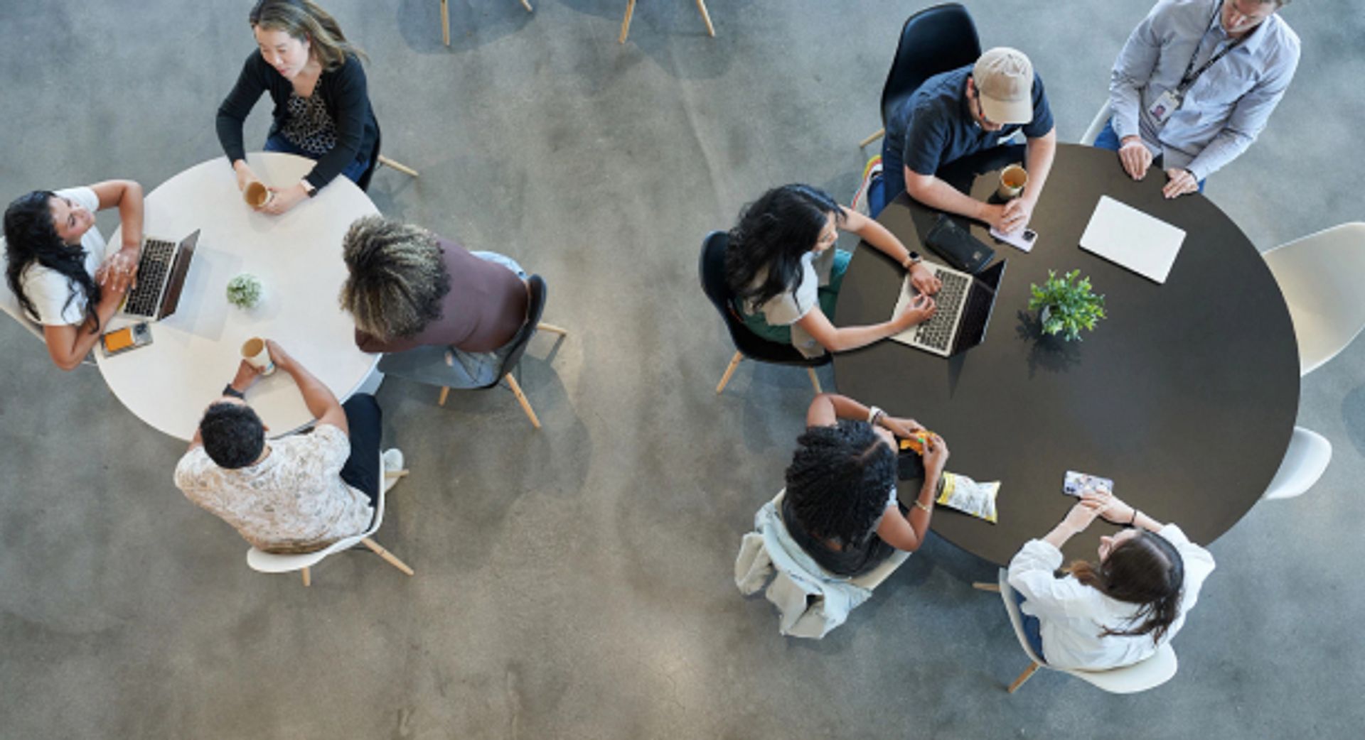 Overhead view of two tables of ByteDance Graduate students as they work on projects.