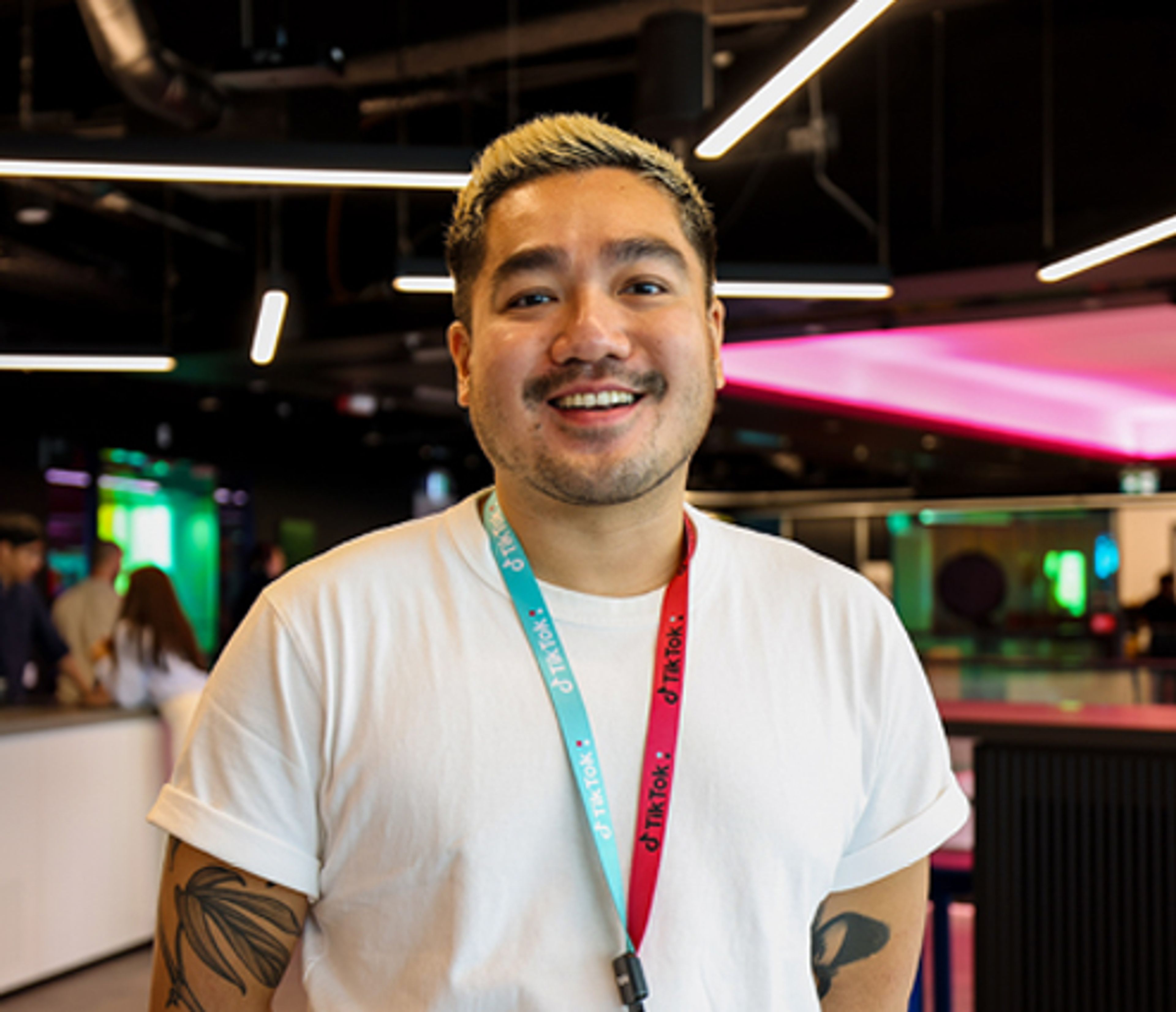 A male and a female TikTok employee sit together, talking and smiling.