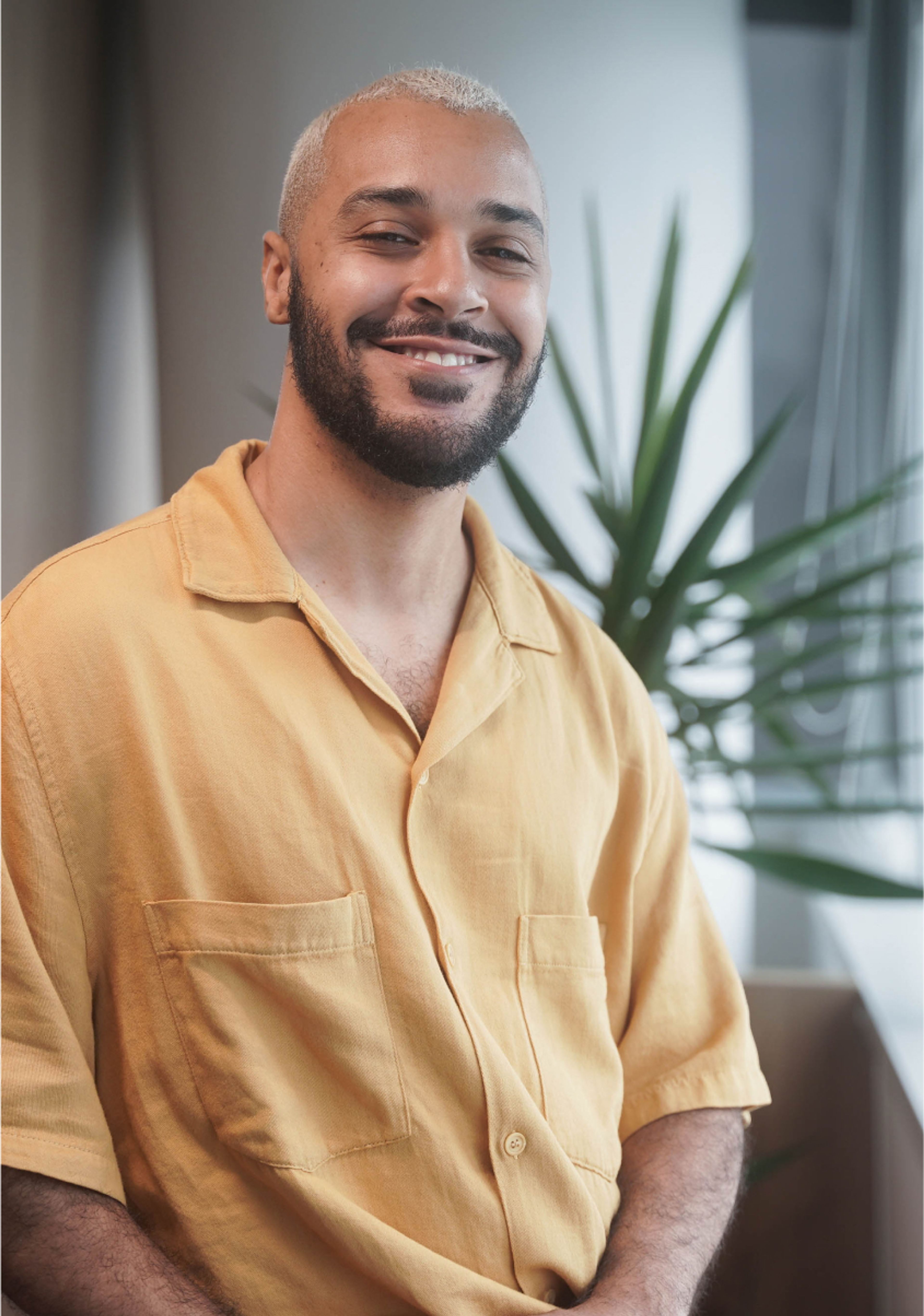 A young male ByteDance employee with a beard sits and smiles at the camera.