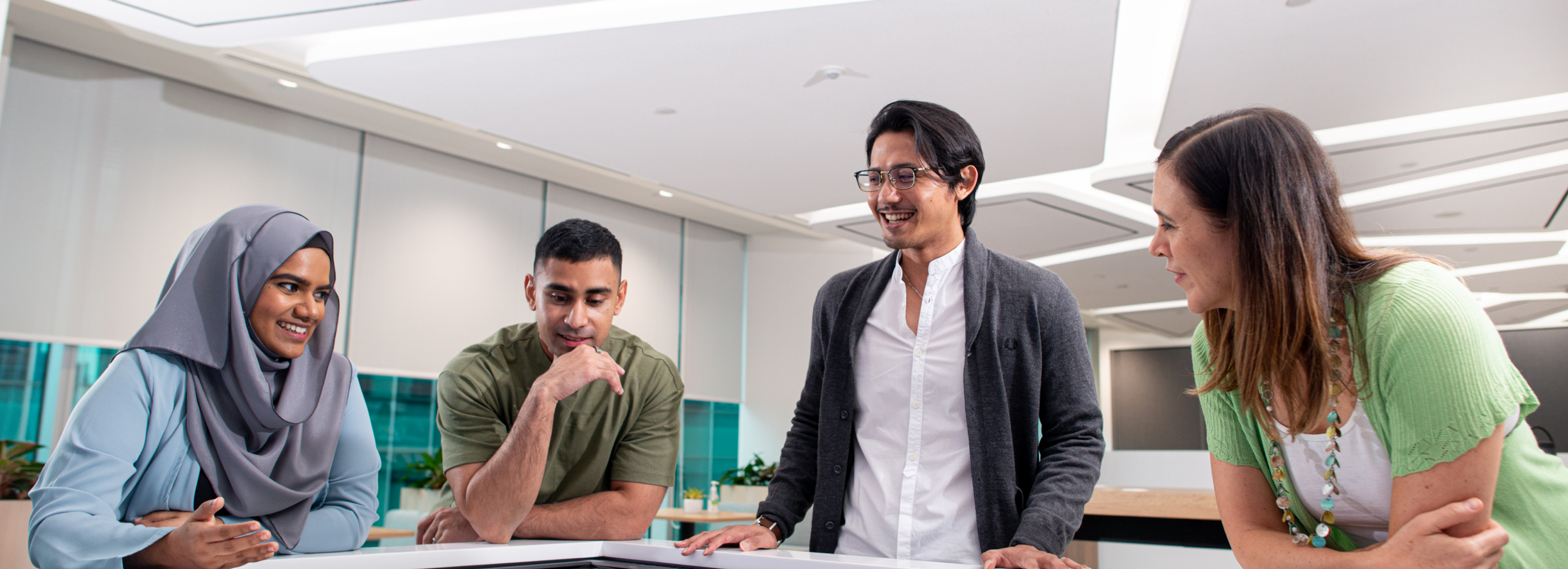 Four ByteDance employees of different ethnicities and genders work on a project.