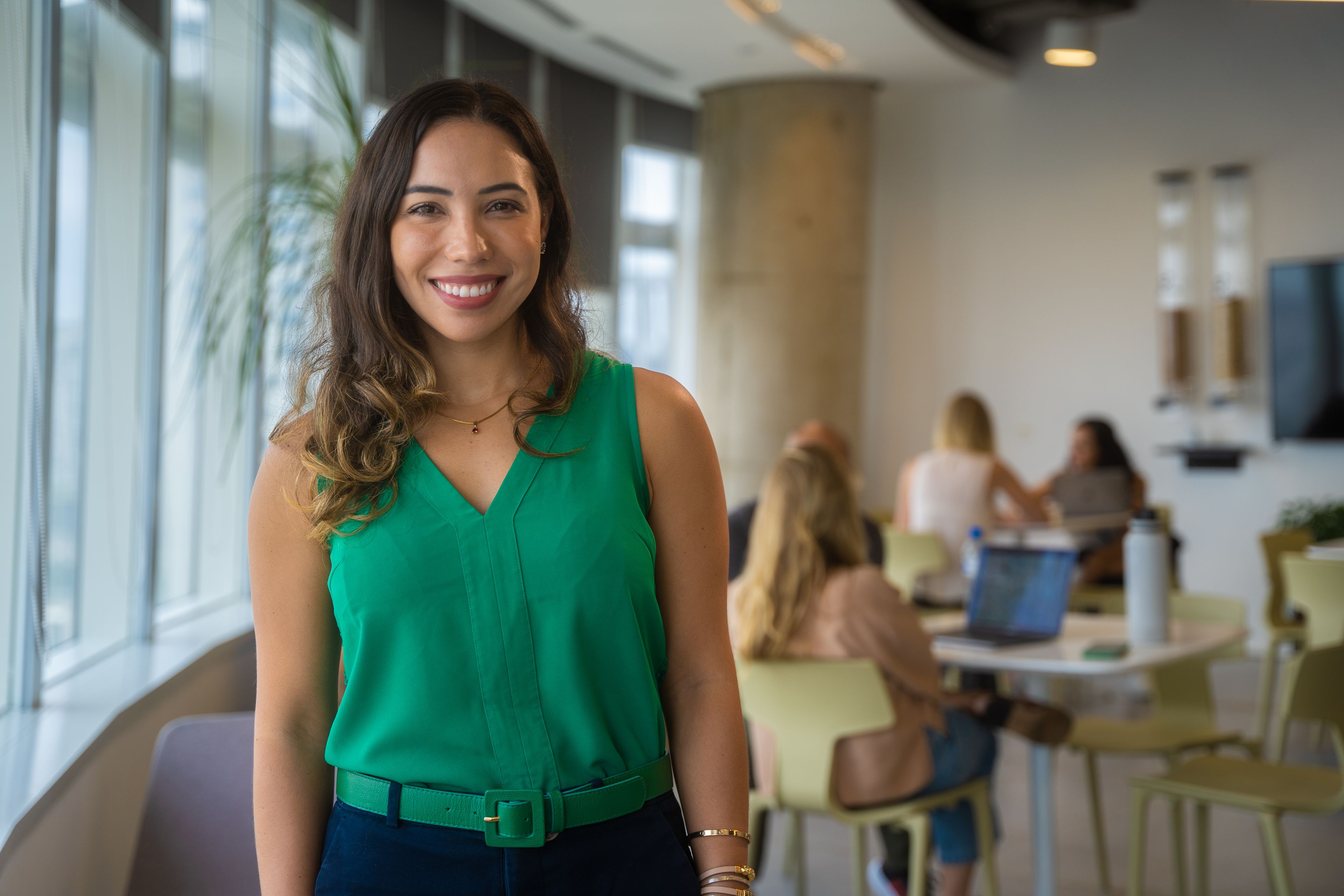 A young female ByteDance employee stands in a ByteDance office and smiles.