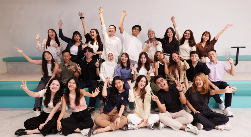 A group of students from the TikTok Shop Graduate Development program pose, wave and smile for a group photo.