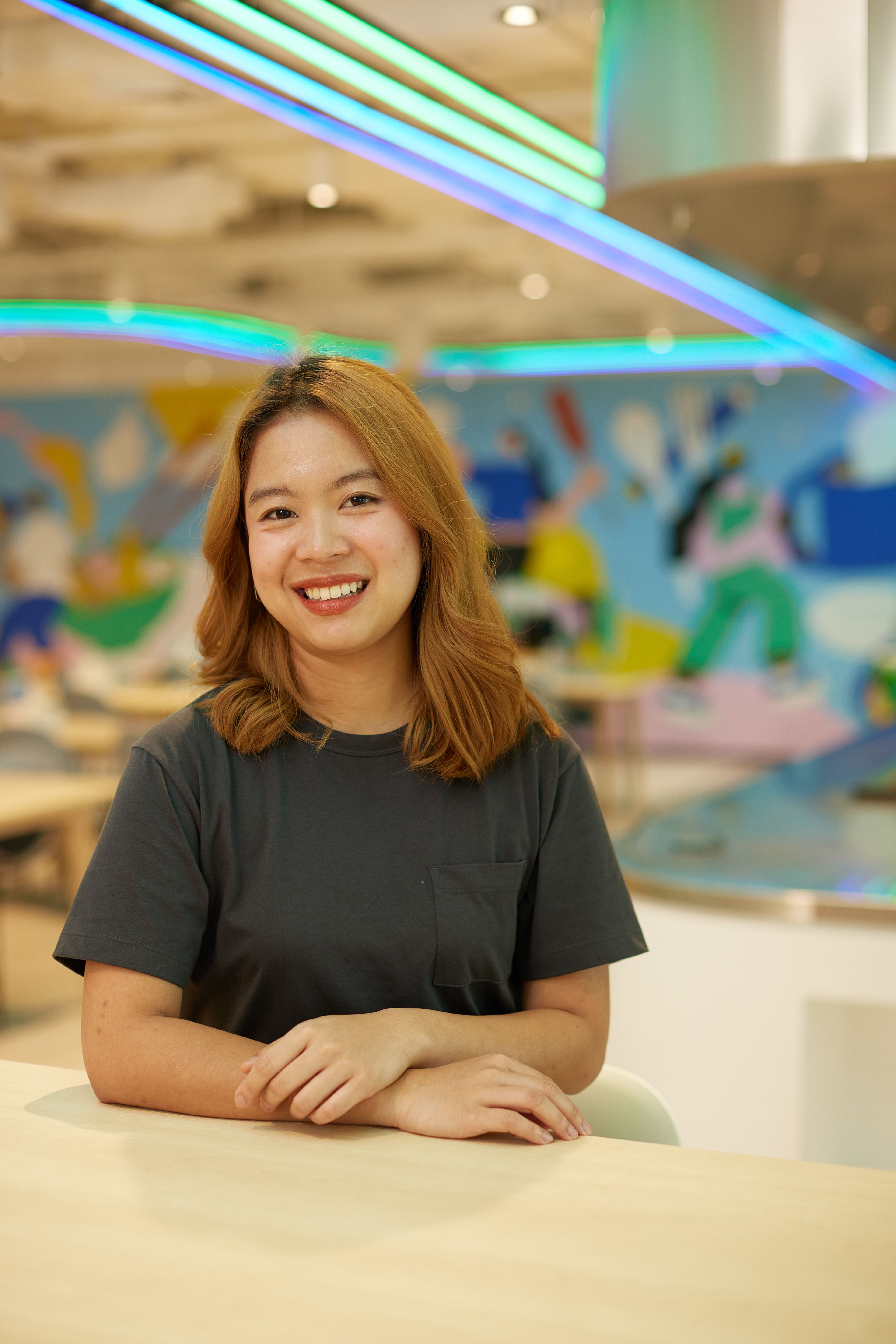 A young female ByteDance employee with light brown hair smiling.