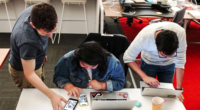 An overhead shot of three TikTok Ph.D. students as they work at their computers.