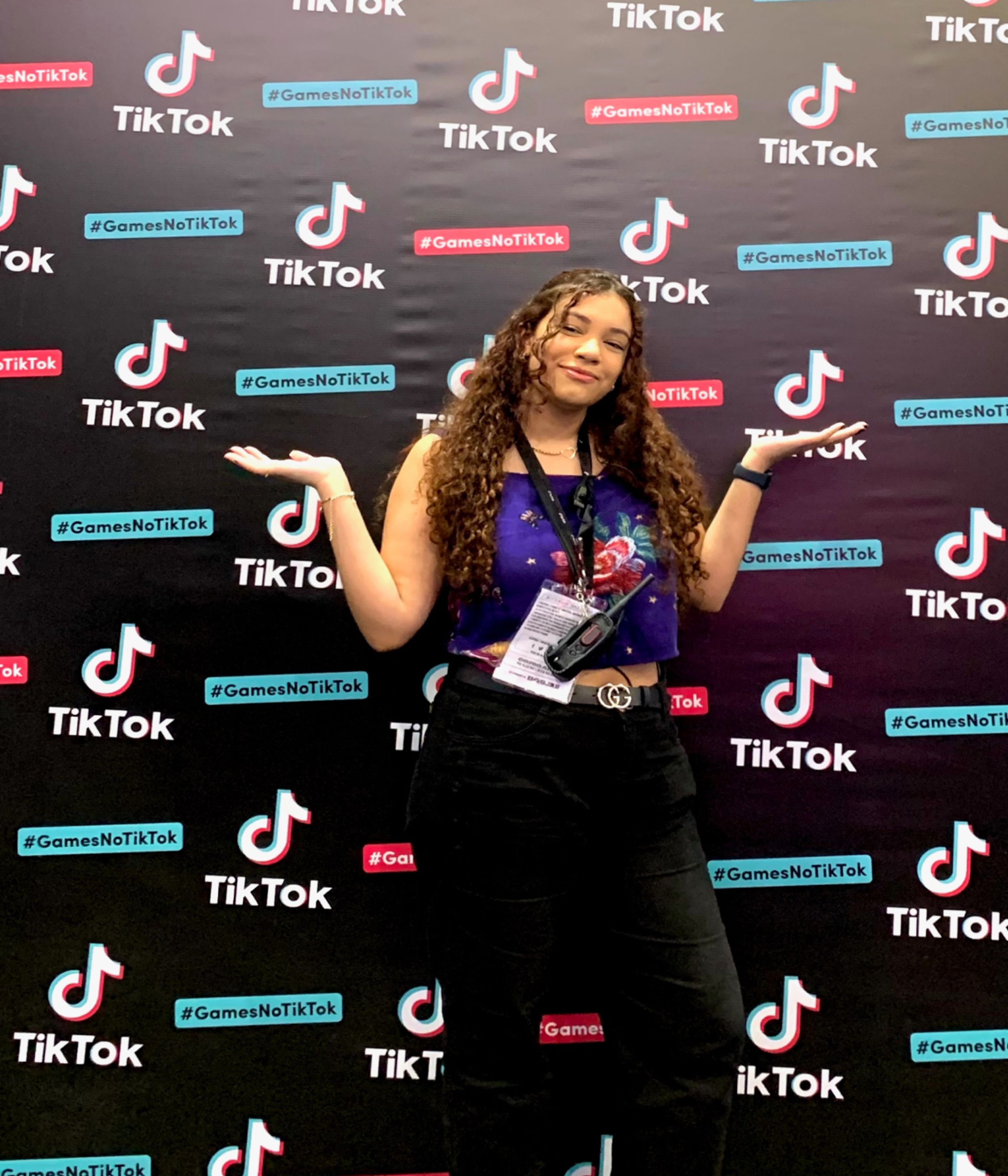 Stephany Santos, a Category Marketing Intern at TikTok, poses in front of a wall covered in TikTok logos.