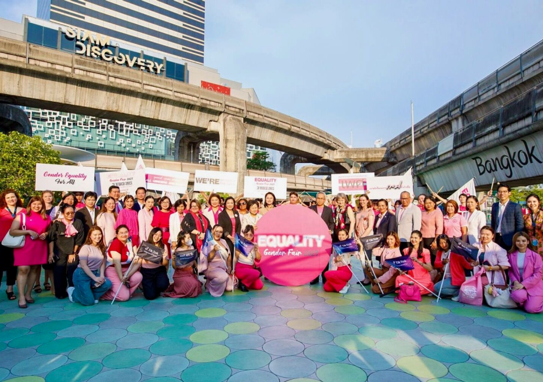 A group TikTok employees wearing pink pose for a group photo at an Equity Gender Fair in Bangkok.