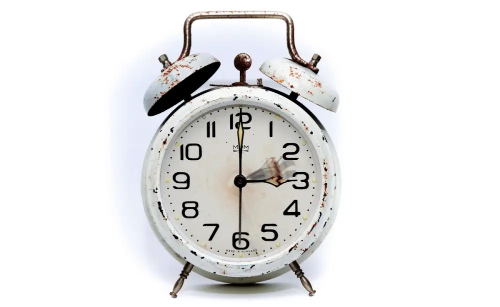Alarm clock on a white background. Looks rusty and indicates defra deadlines for DWT