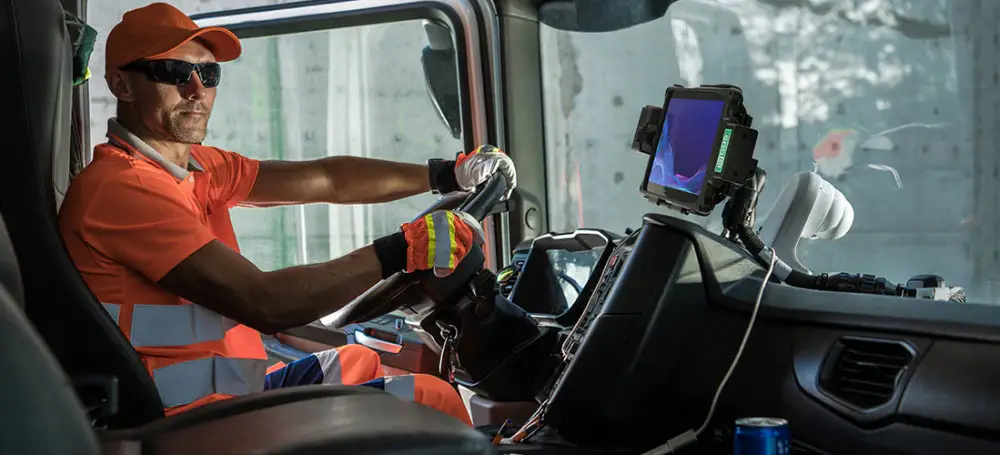 Man in a waste truck with a digital screen for saving electronic waste notes automatically