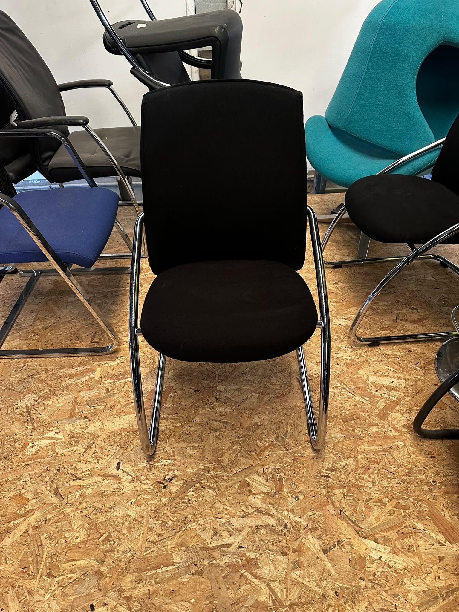 Chaise visiteur noire – Assise rembourrée et piètement luge chromé