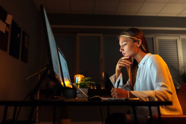 Woman in front of screen transcribing a YouTube video by hand