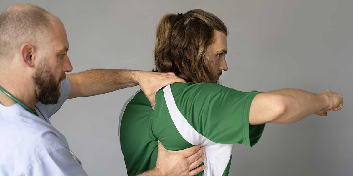 A practitioner examines a patient's upper back and shoulder muscles to evaluate and treat painful muscle knots.