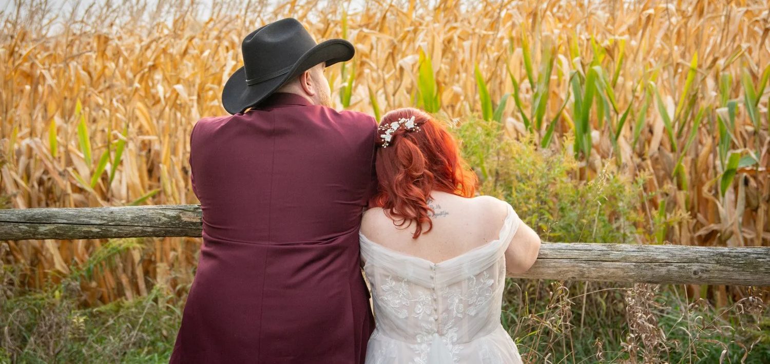 Just married farm wedding bride and groom looking out at the fields.