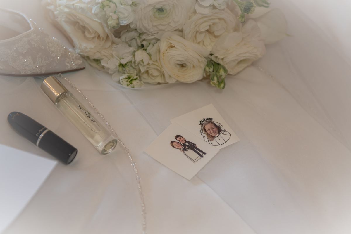 A serene moment captures Carmela's wedding preparations, featuring a bouquet of white ranunculus and personal items.