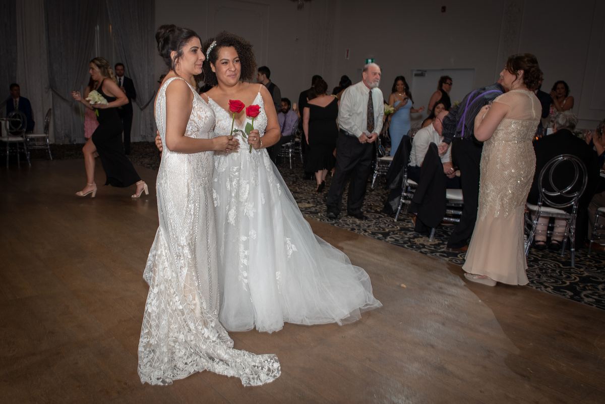 Two brides, Alexa and Nazareth, share a tender moment on the dance floor at their wedding reception.