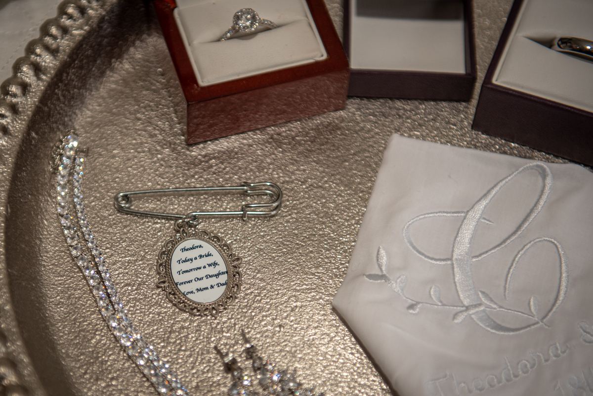 Wedding trousseau items including ring, safety pin, necklace, and handkerchief create an elegant scene.